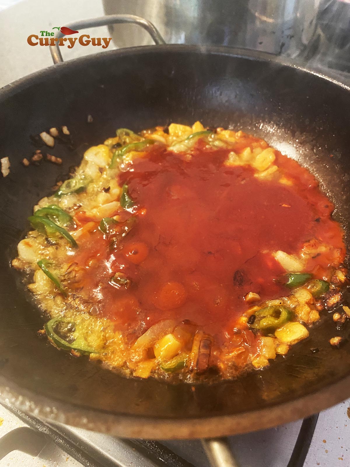 Pouring tomato and chilli sauce in. 