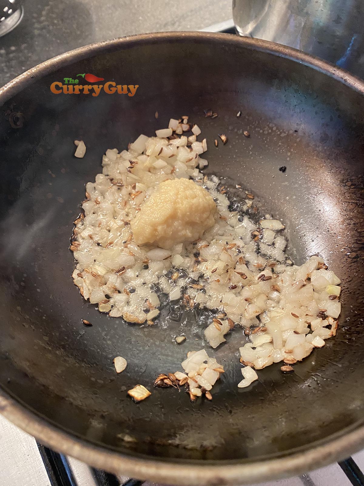 Adding garlic and ginger paste to pan