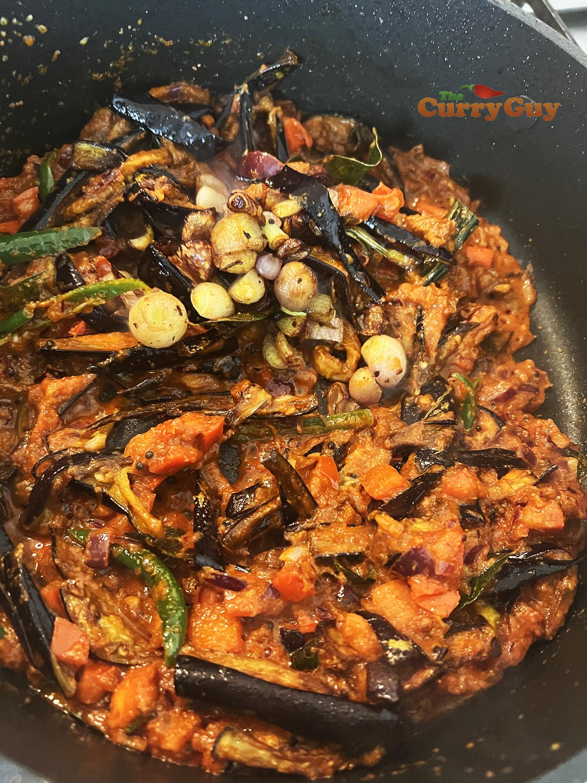 Adding eggplant and shallots to pan