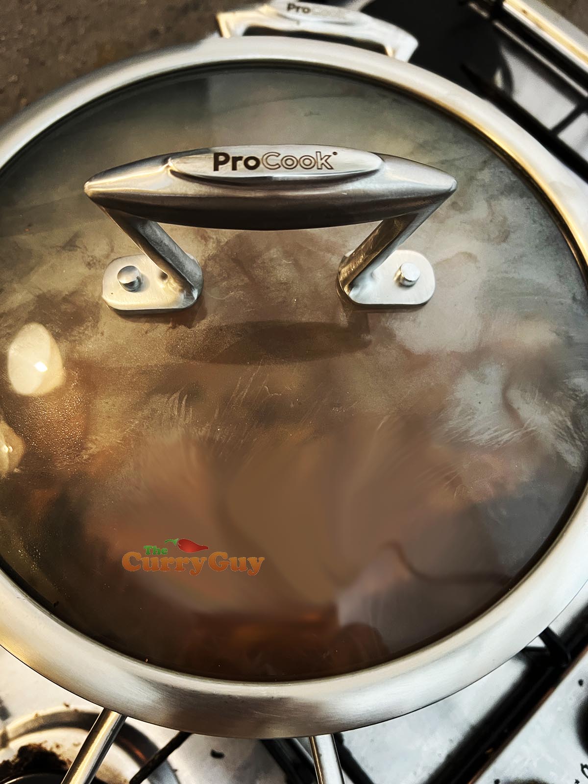 Covering the pan to slowly cook the curry