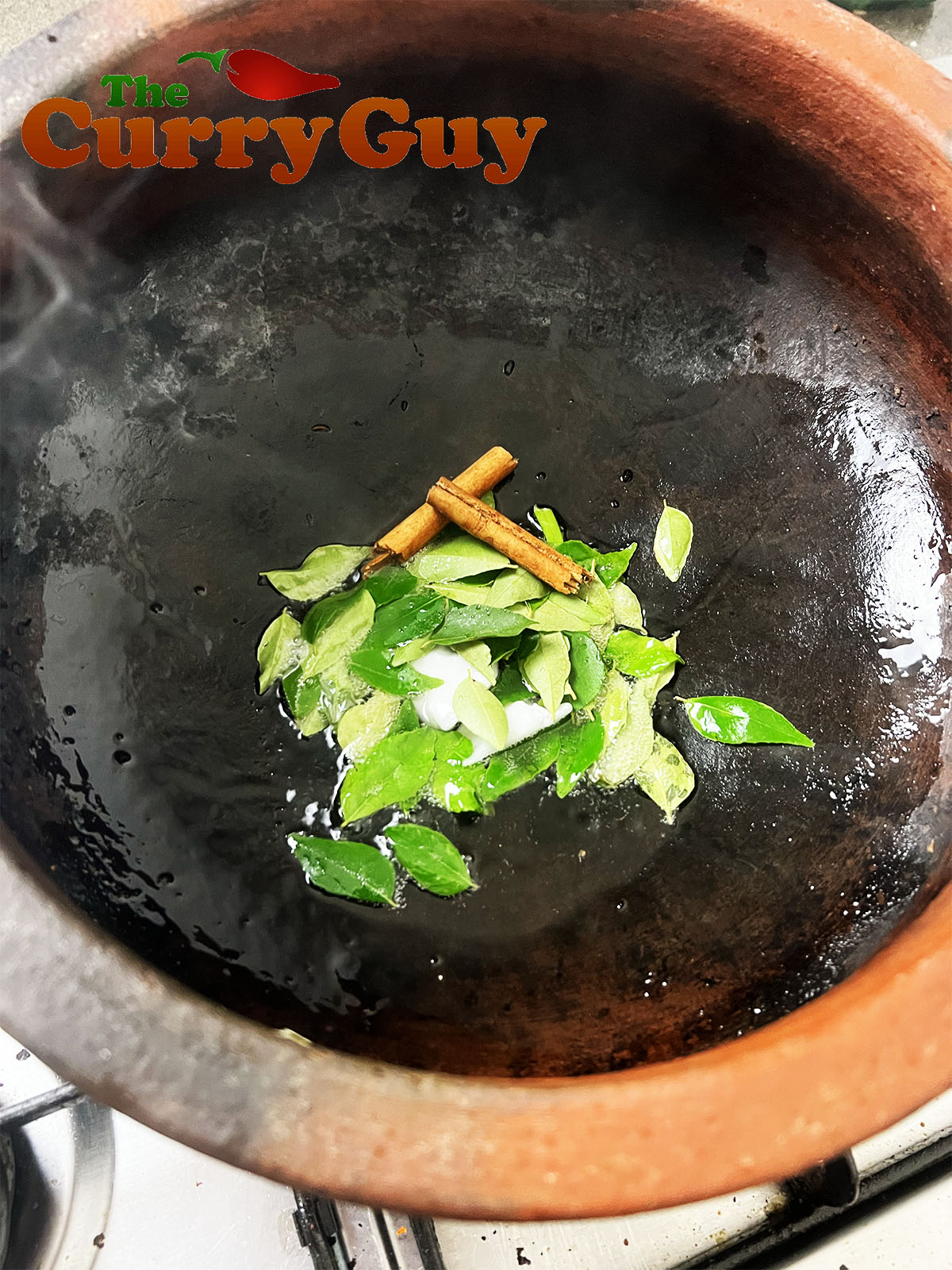 Infusing the curry leaves and cinnamon into the coconut oil