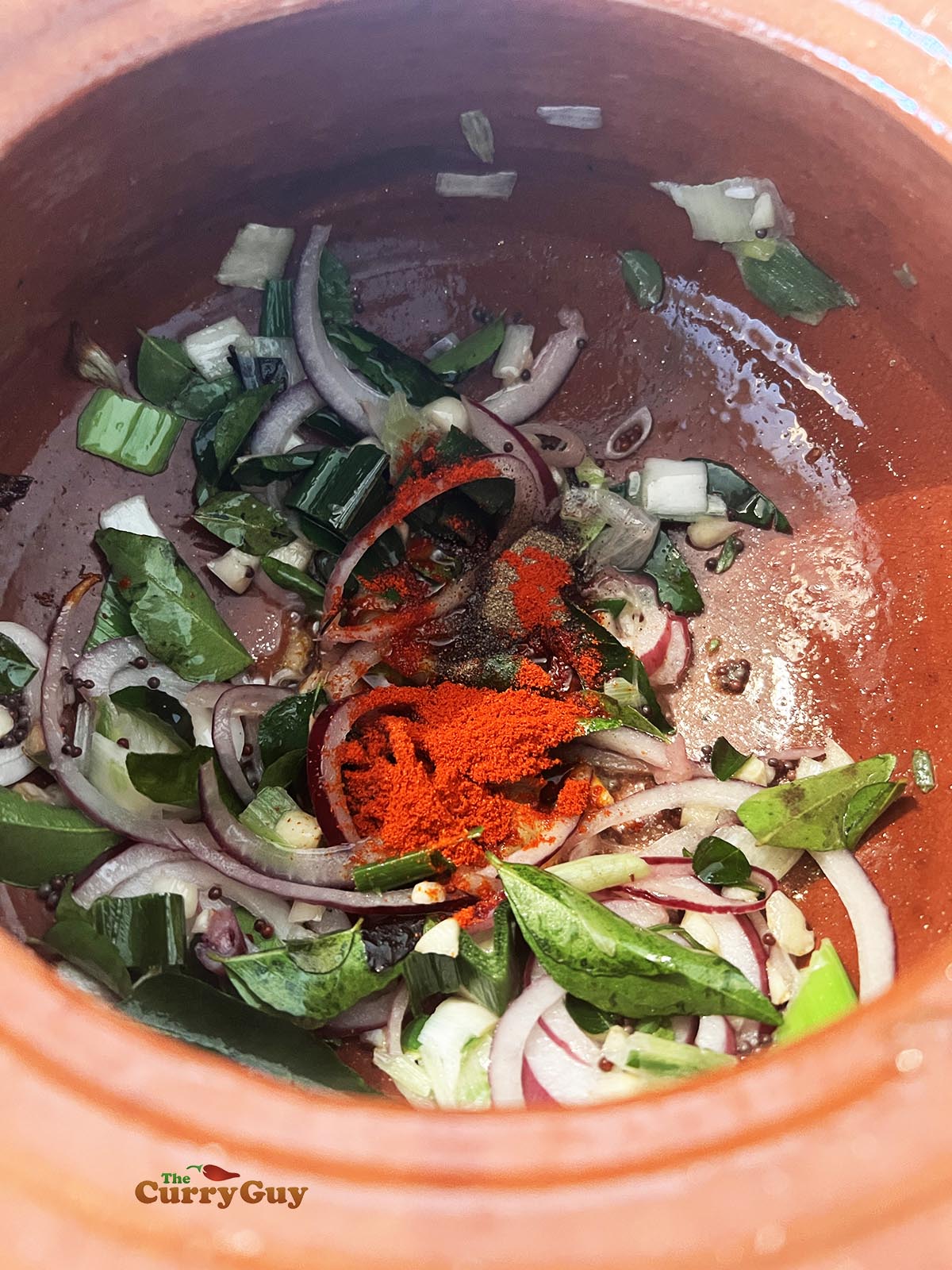 Adding chilli powder to curry