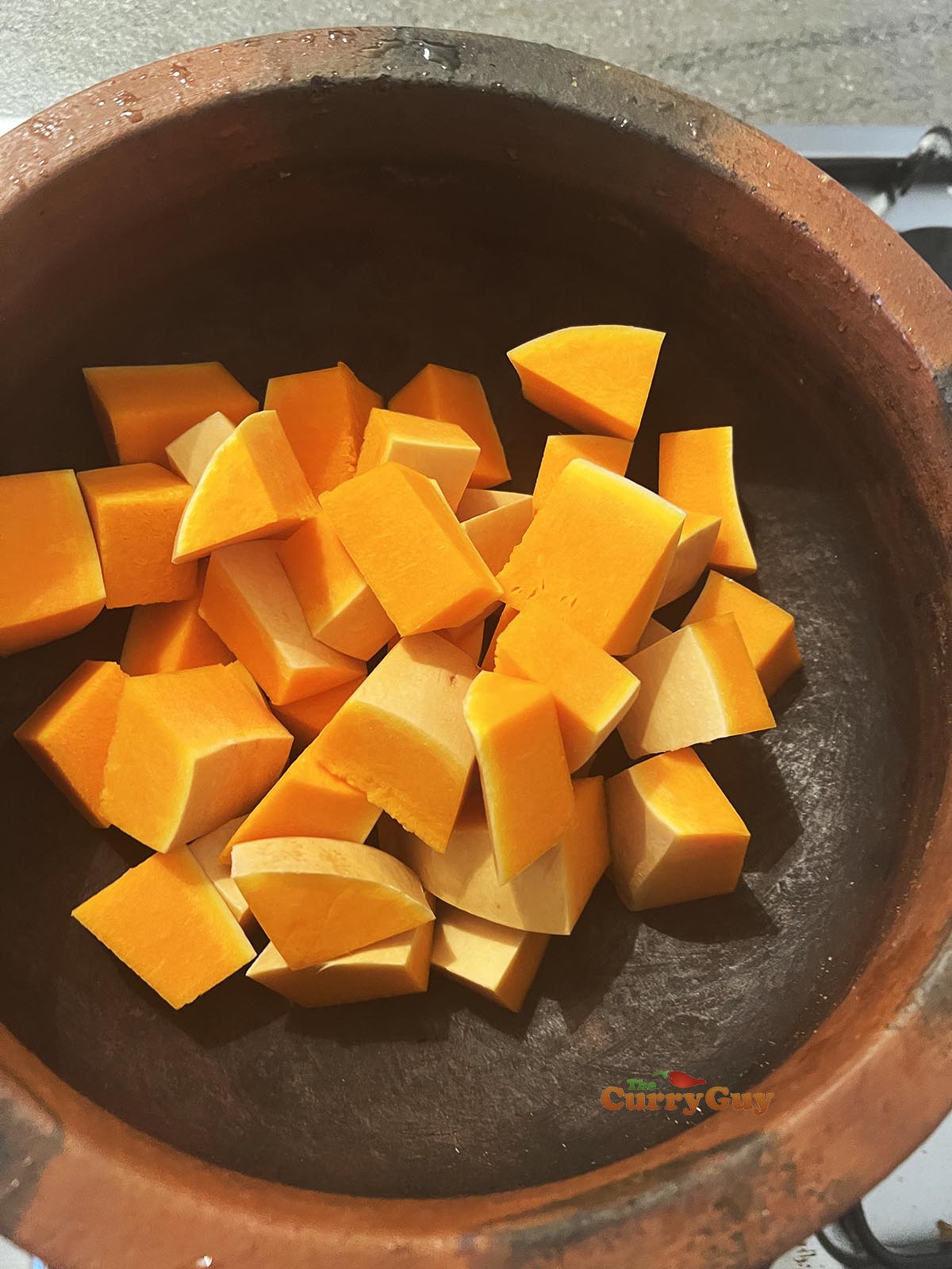 Placing cubed butternut squash into pot