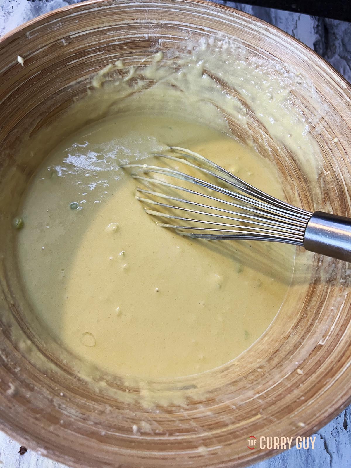 Whisking the batter ingredients together until smooth.