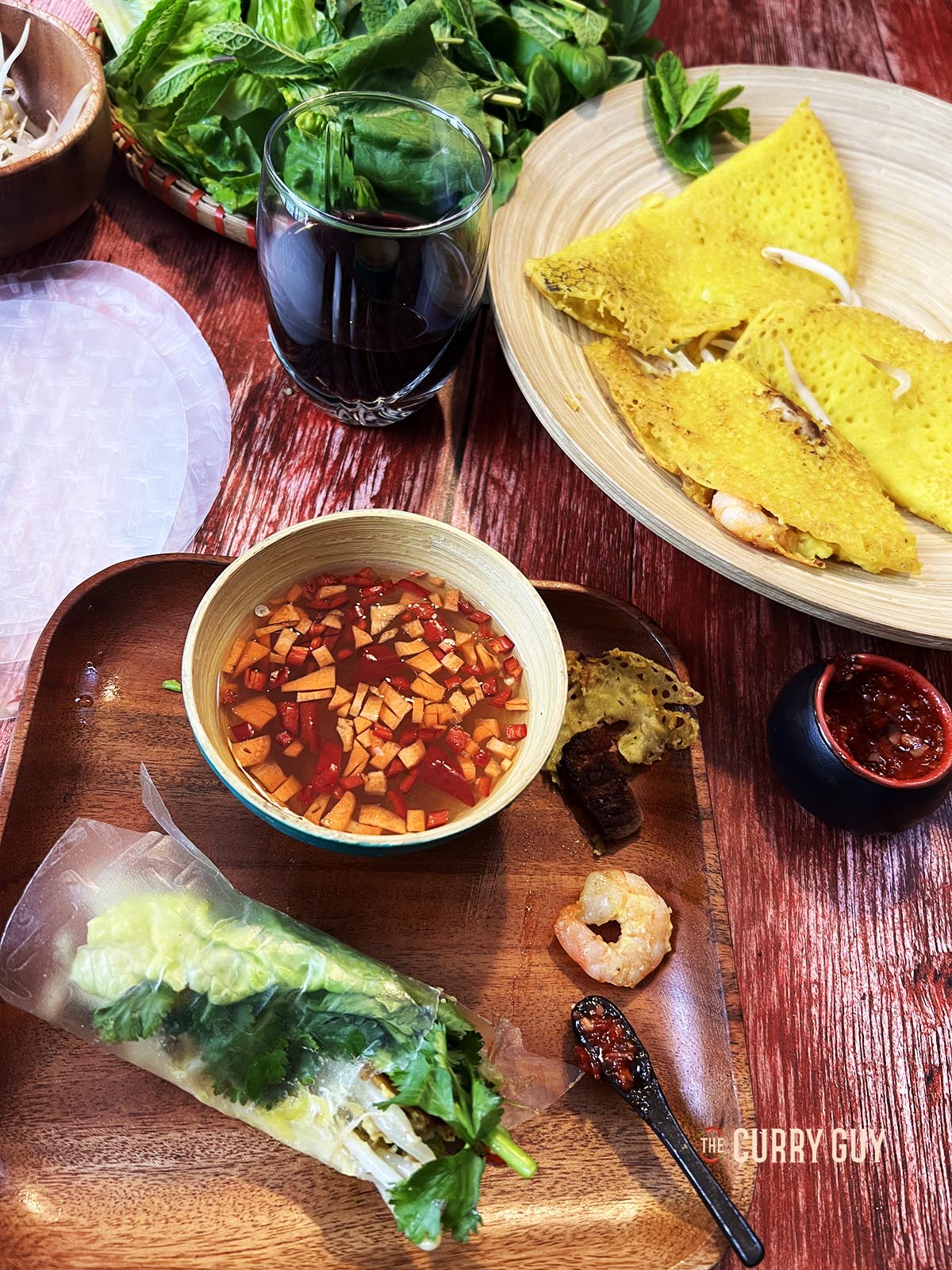 Banh xeo wrapped in soft rice paper with herbs. 