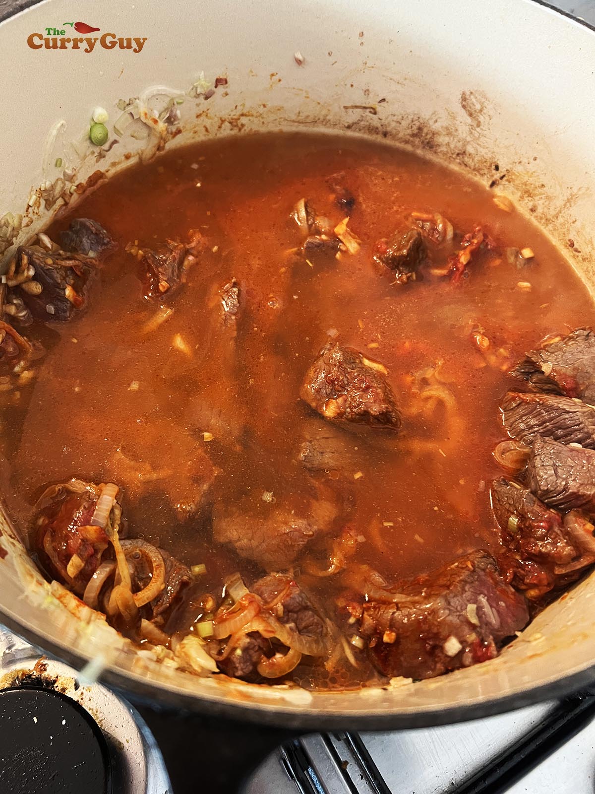 Adding chopped tomatoes to the Bo Kho
