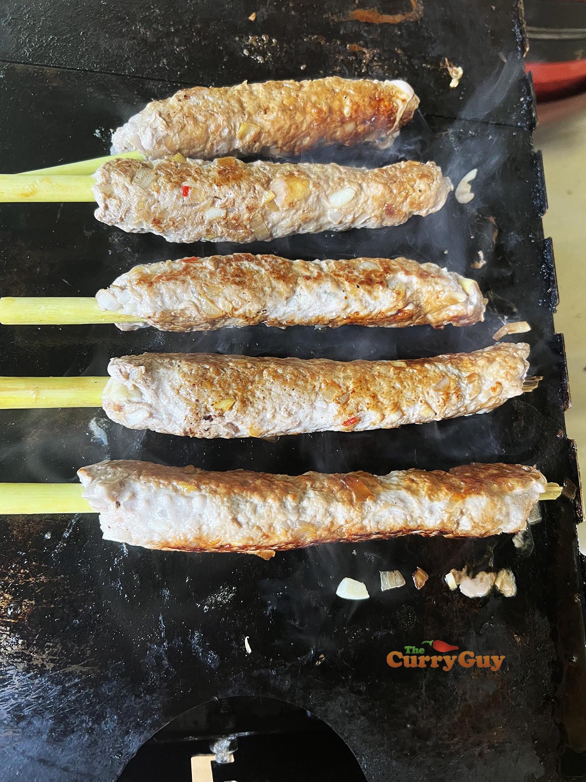 Frying pork and lemongrass skewers
