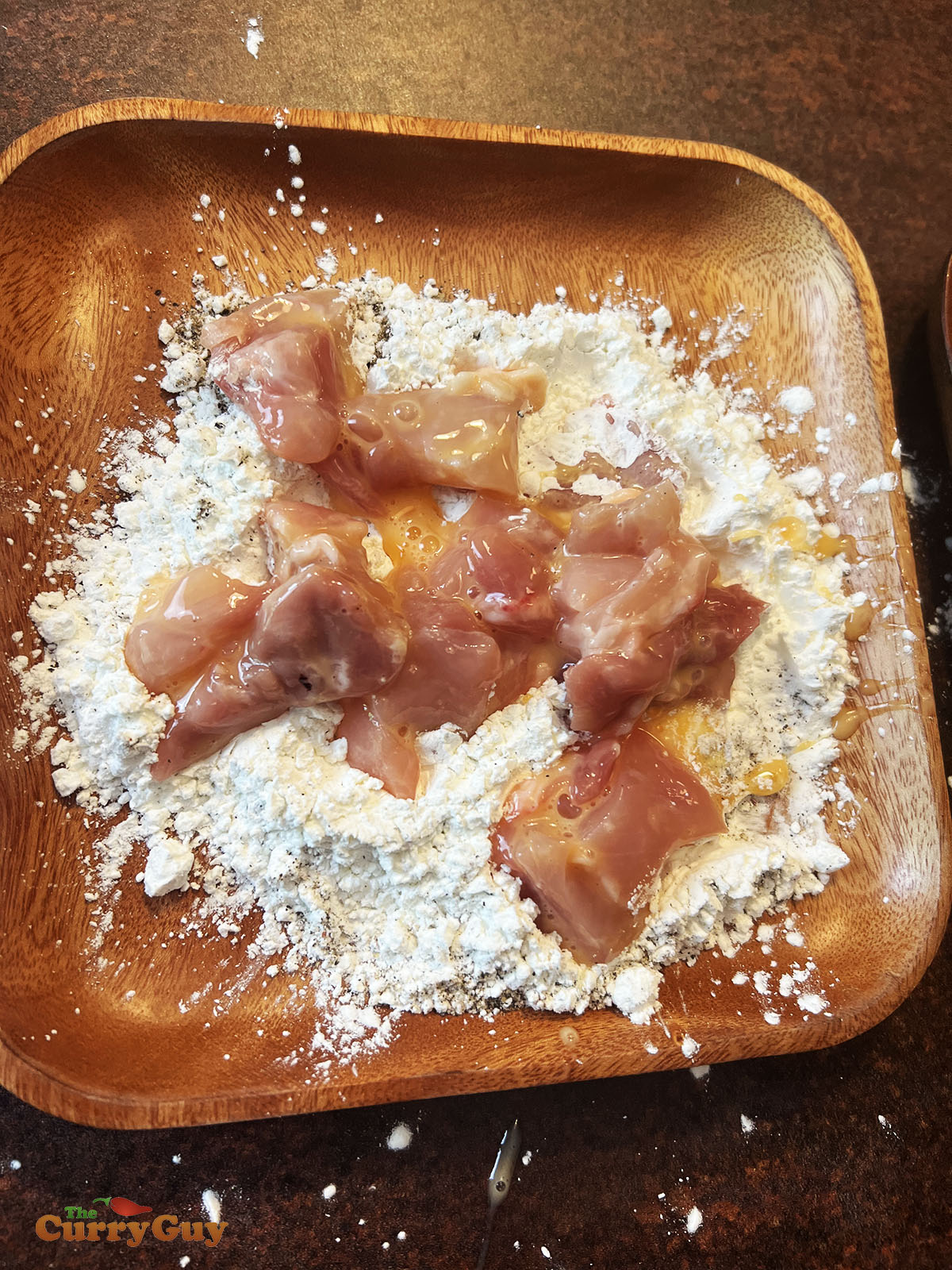 Dusting chicken pieces with flour.