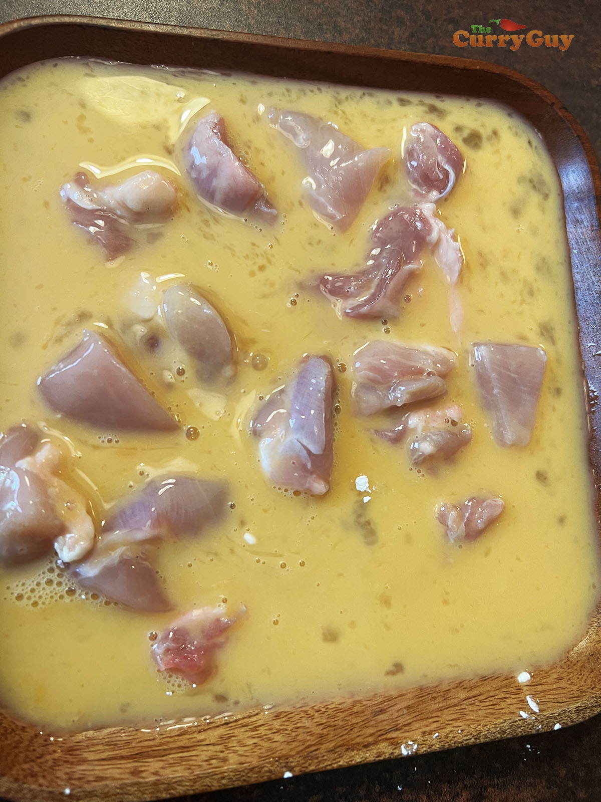 Dipping chicken in egg wash