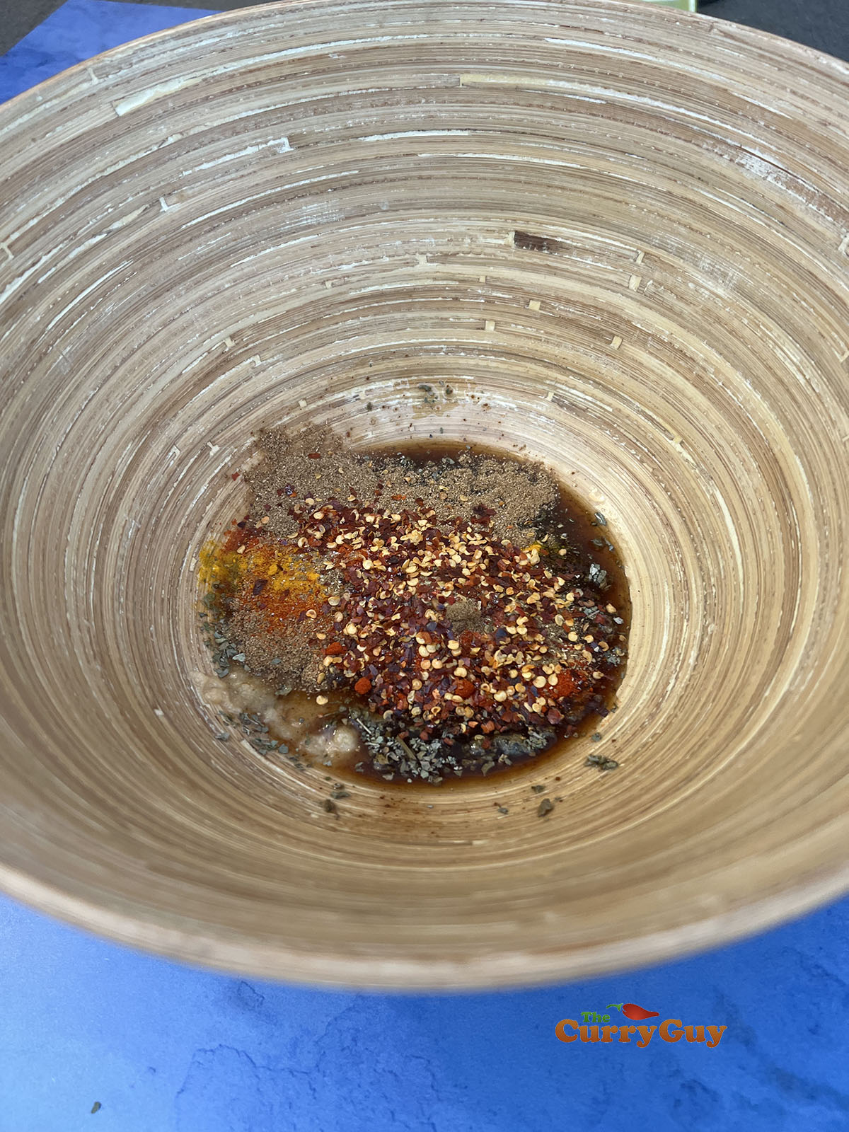 Adding tamarind and spices to the mixing bowl