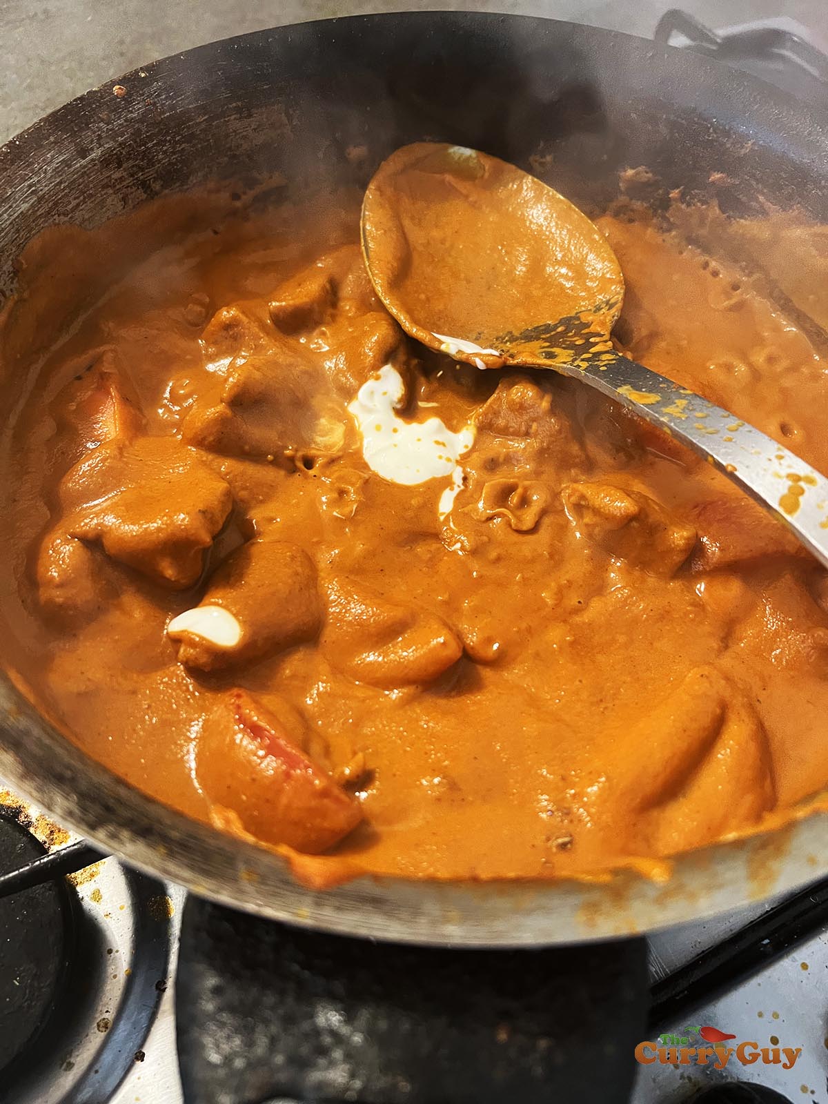 Adding yoghurt to the sauce.