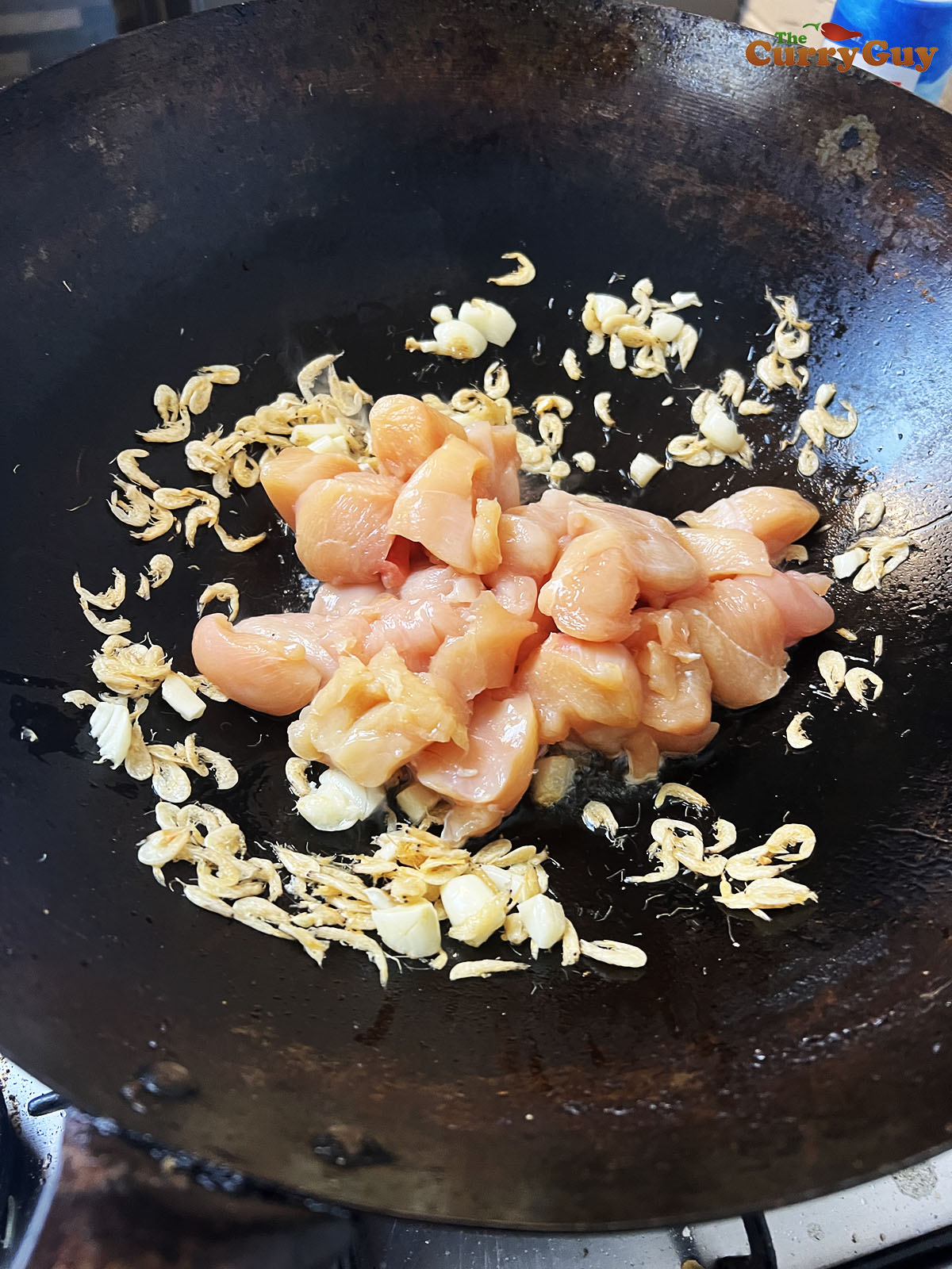 Adding chicken to the wok