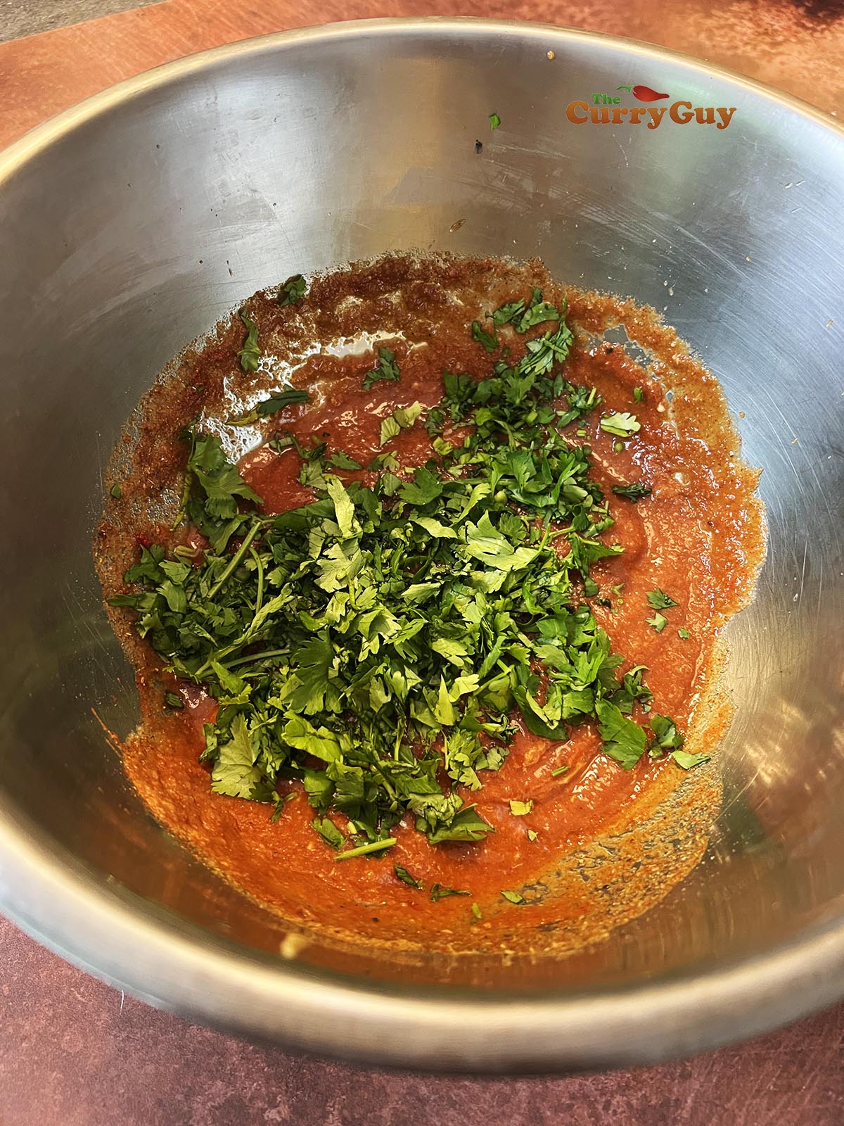Adding coriander (cilantro) to the marinade.