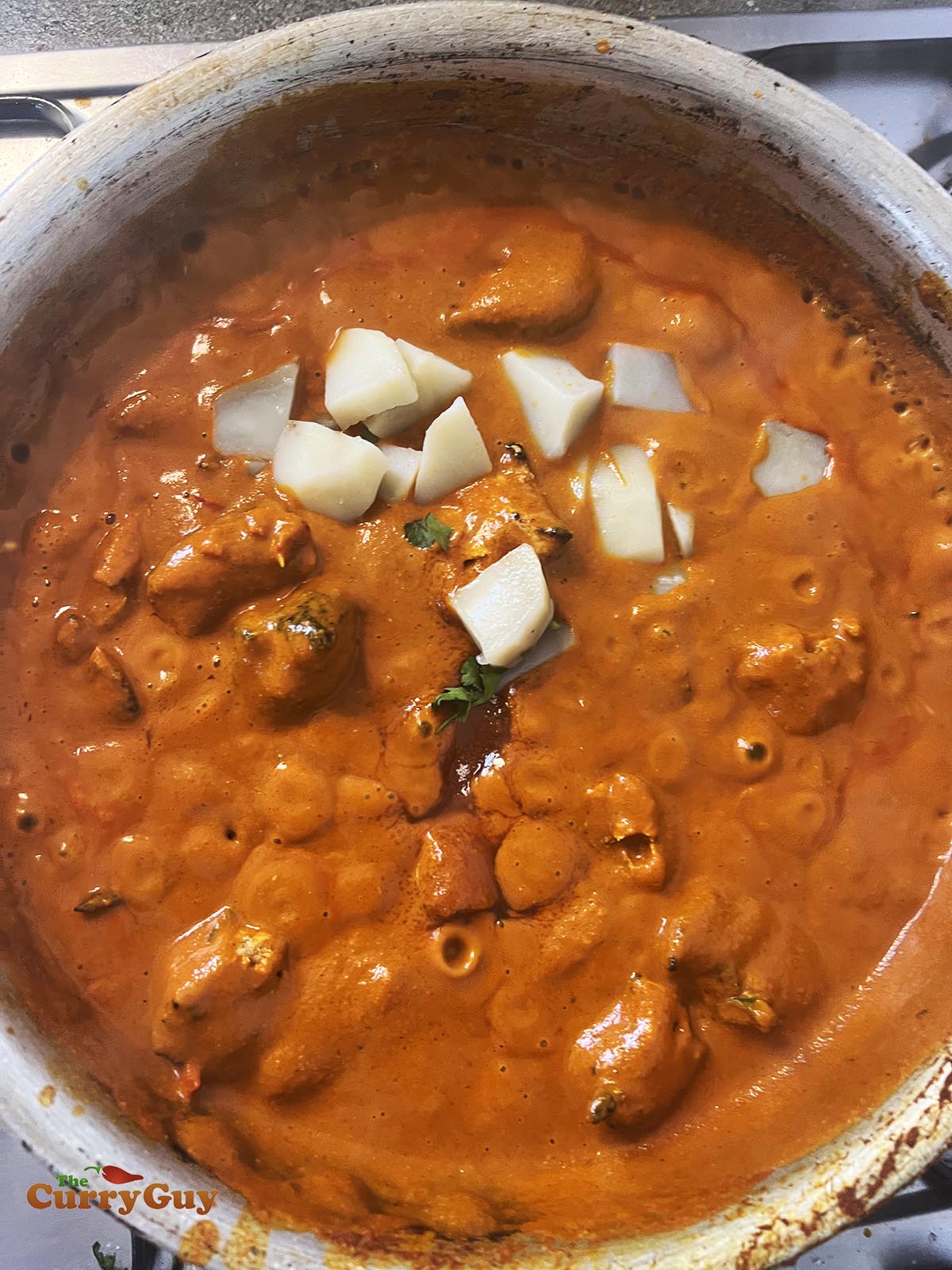 Adding potatoes to the sauce.