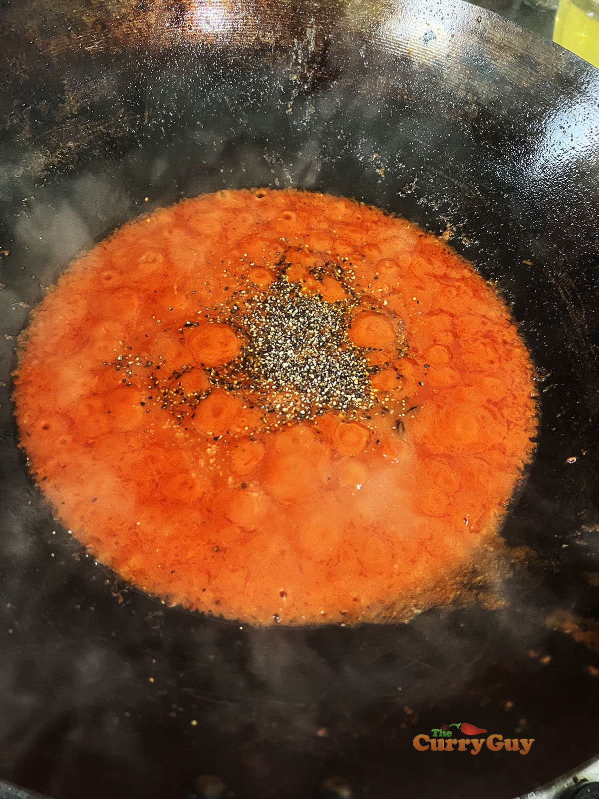 Adding black pepper and coconut milk to wok