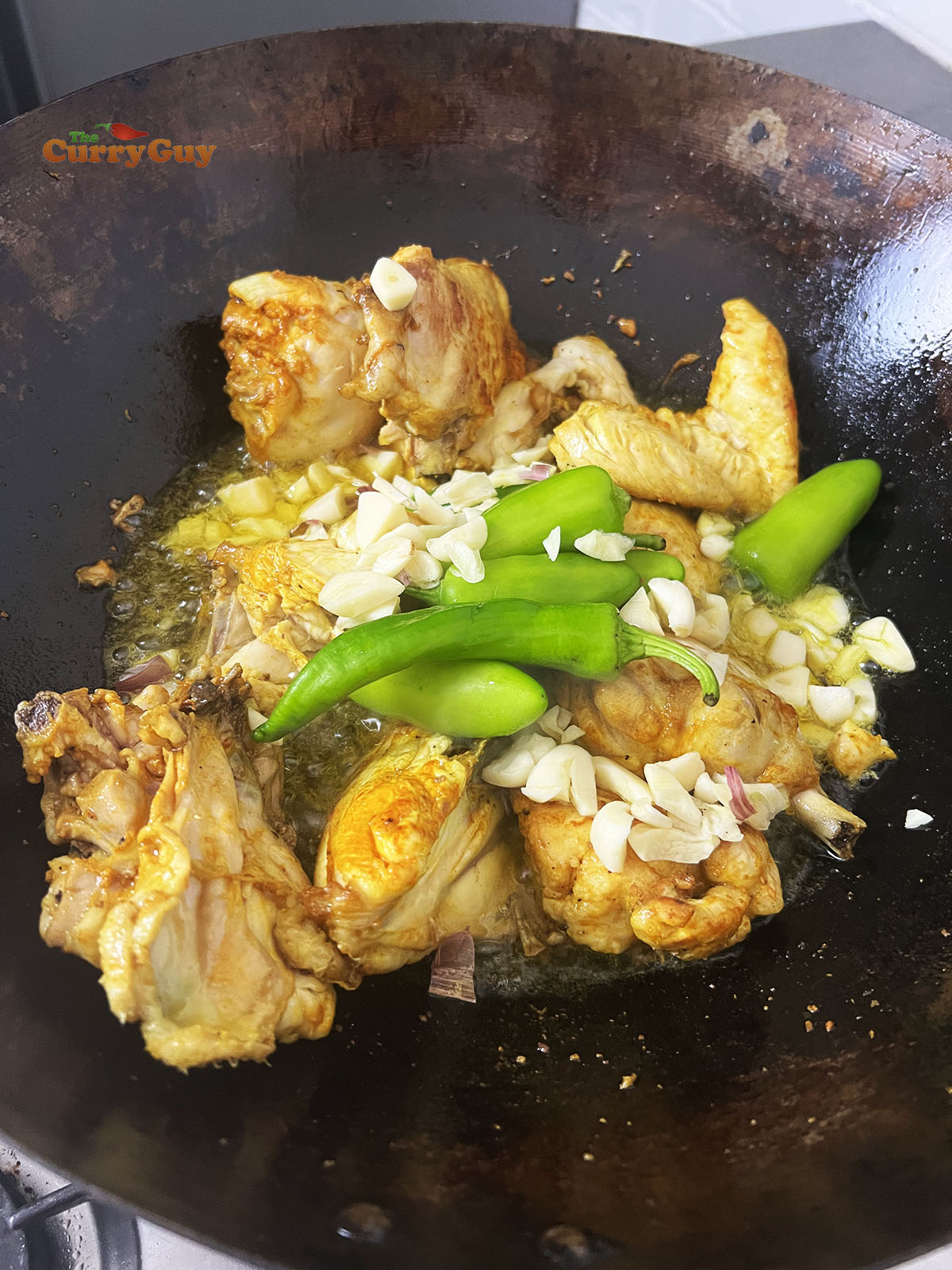 Adding garlic and chillies to the pan