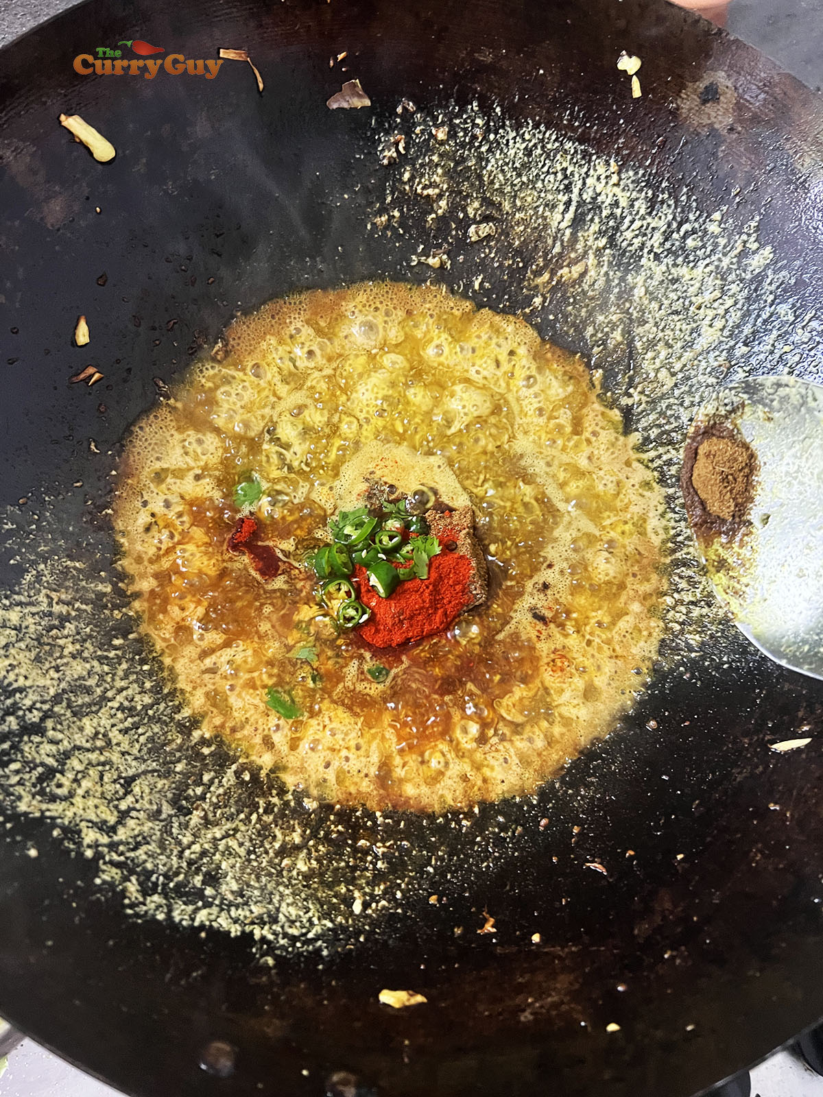 Adding chopped chillies and ground spices to the pan