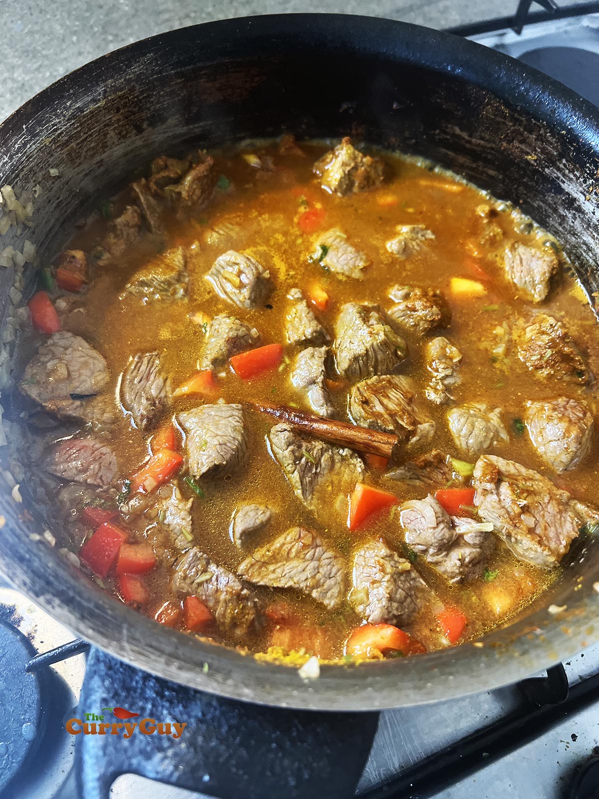 Adding bell pepper, spices and water to pan