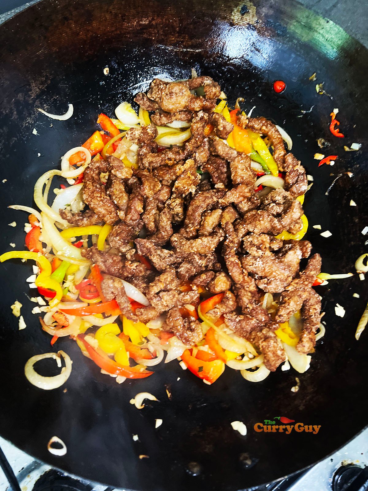 Adding crispy fried beef to the wok