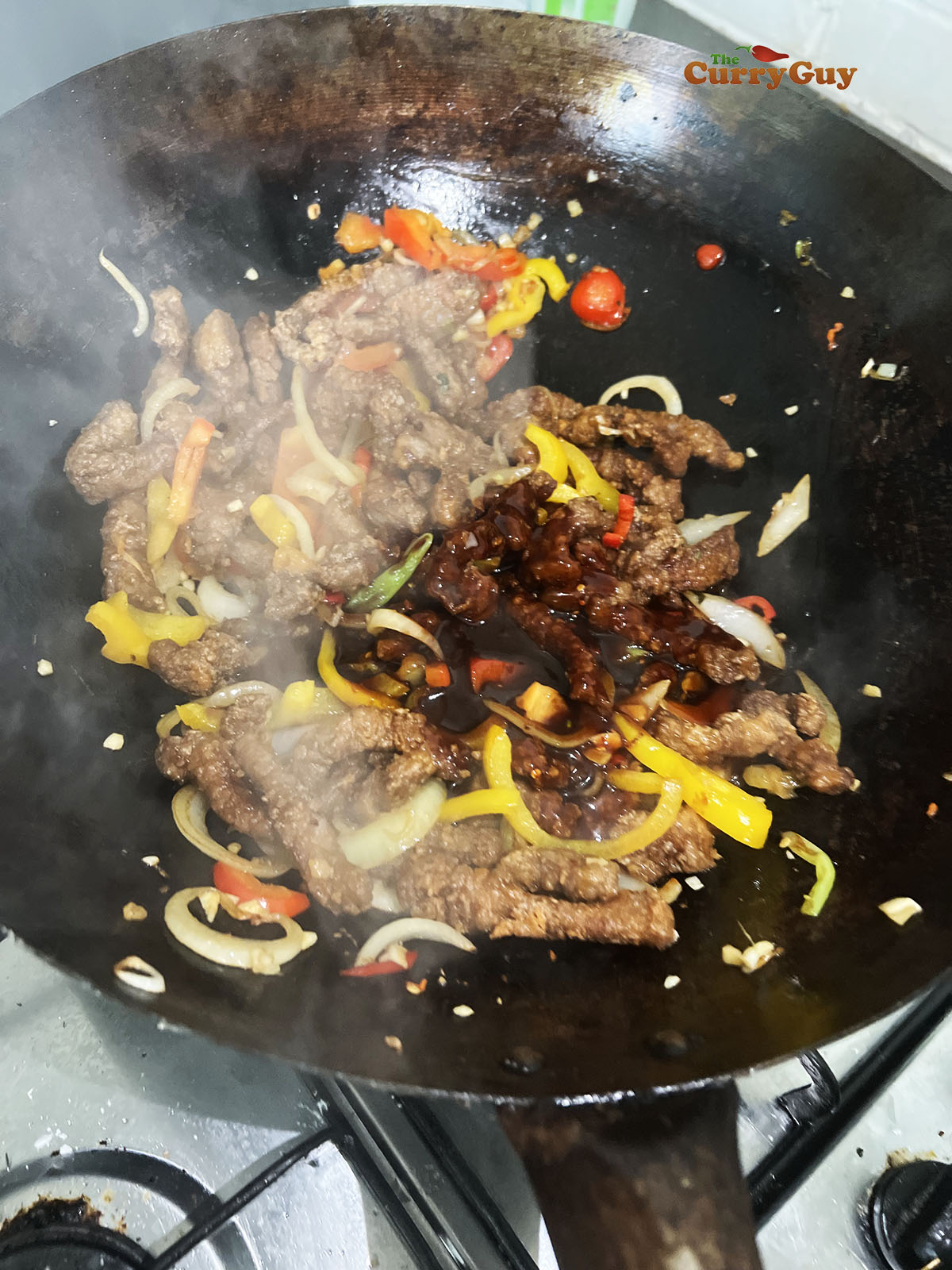 Adding the sauce to the wok