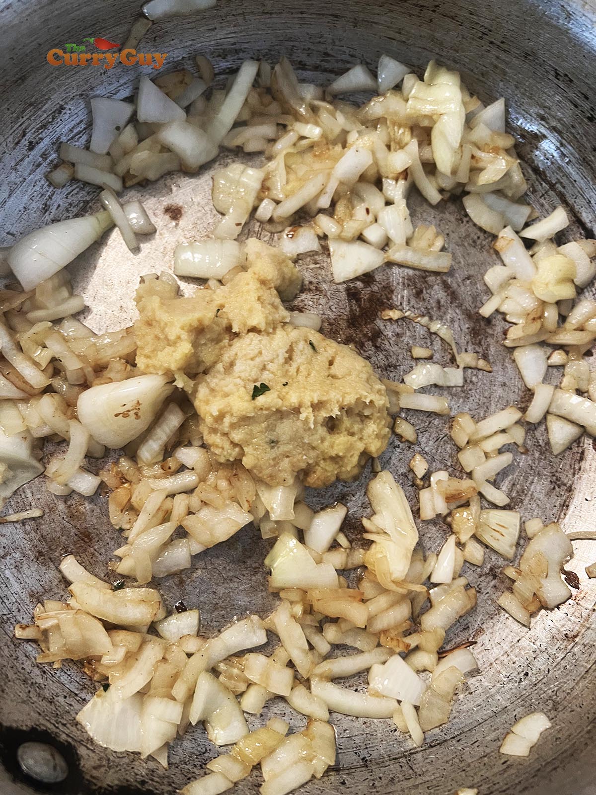 Adding onions and garlic and ginger to pan