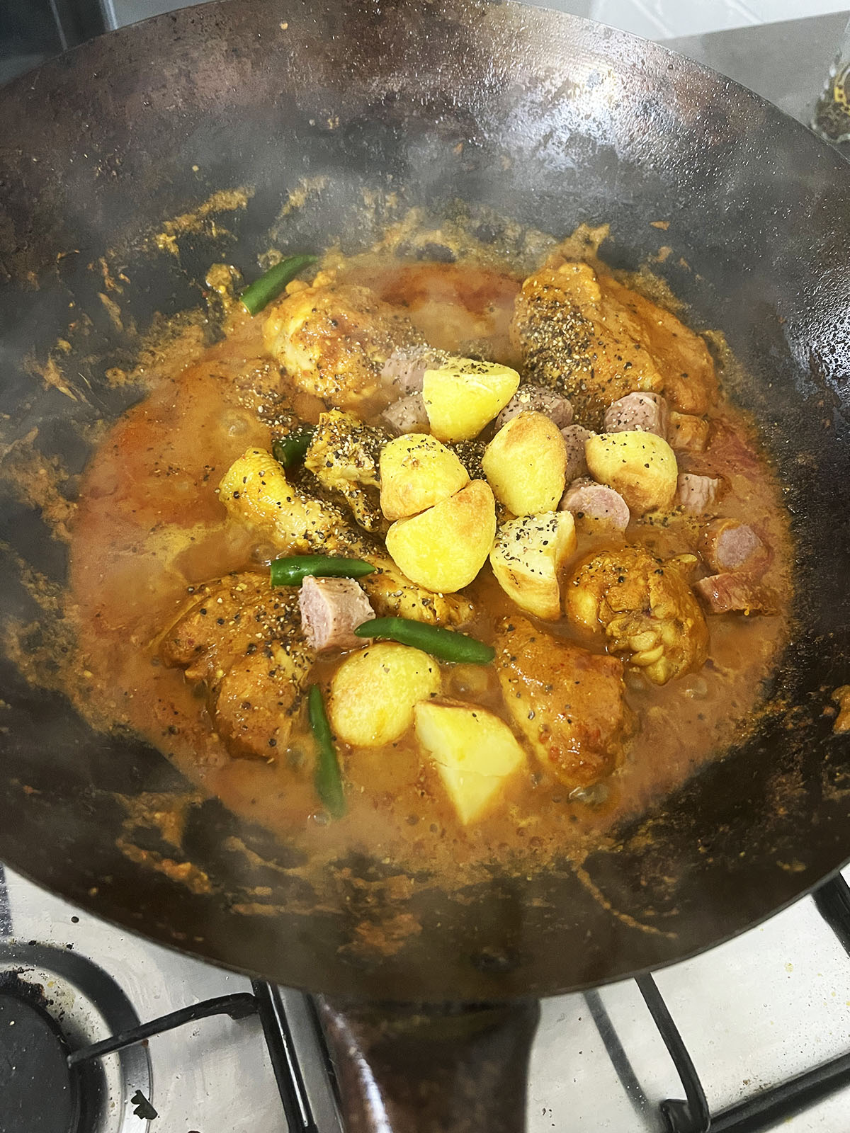 Simmering chicken, potatoes and sausages.