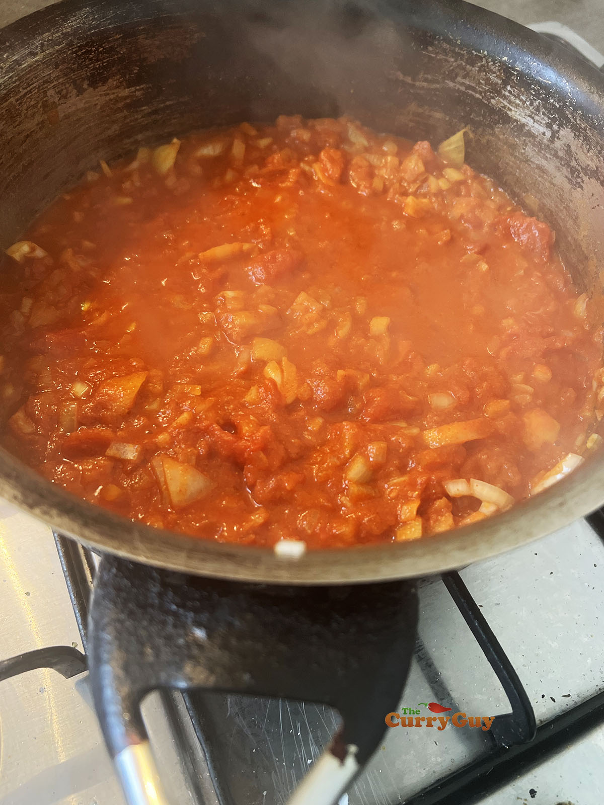 Adding tomatoes, stock and pineapple juice to the pan