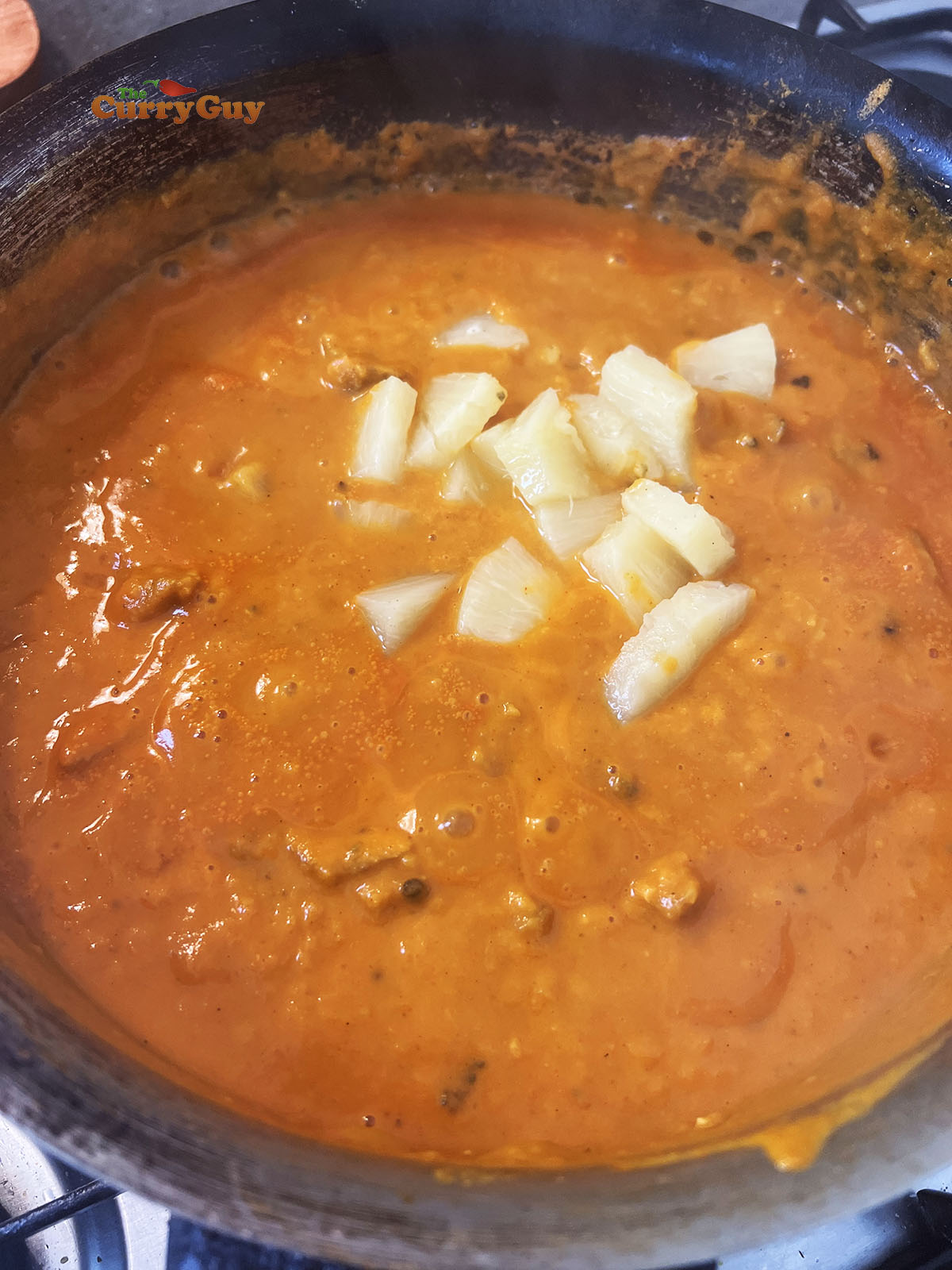 Adding the optional pineapple to the curry
