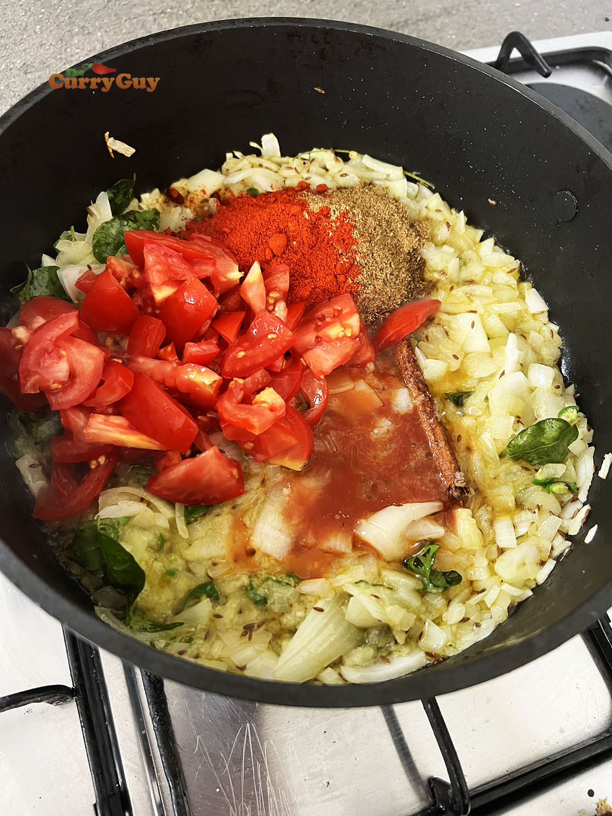 Adding tomatoes and ground spices to the pan