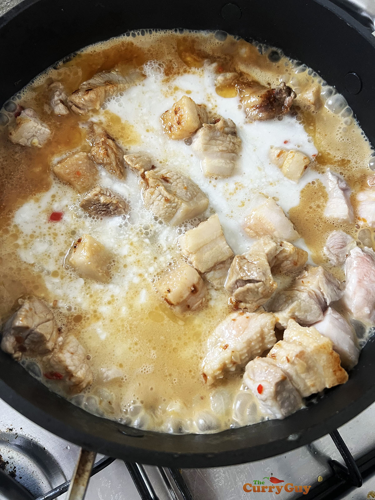 Adding coconut milk and water to the pan