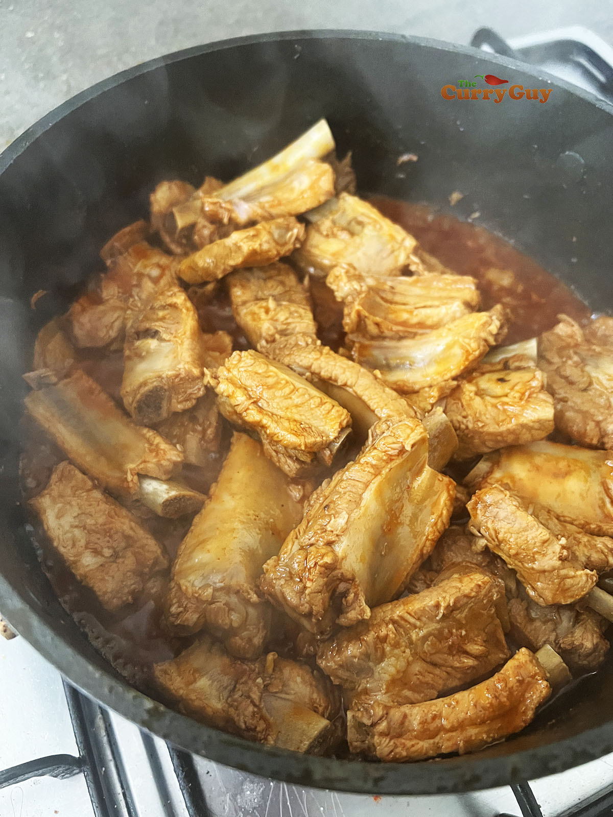 Simmering the ribs until the sauce is thick