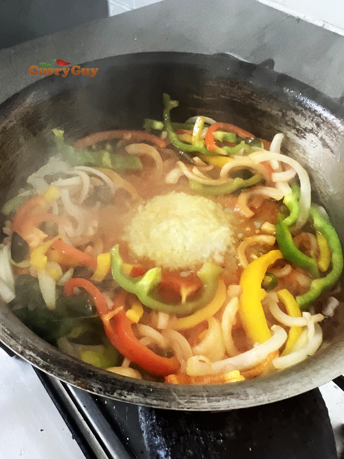 Adding garlic and ginger paste and tomato puree to the pan