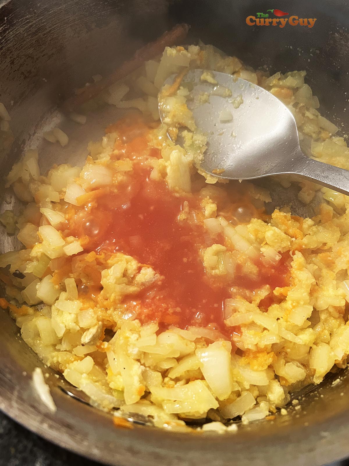 Adding tomatoes and chicken stock to the pan