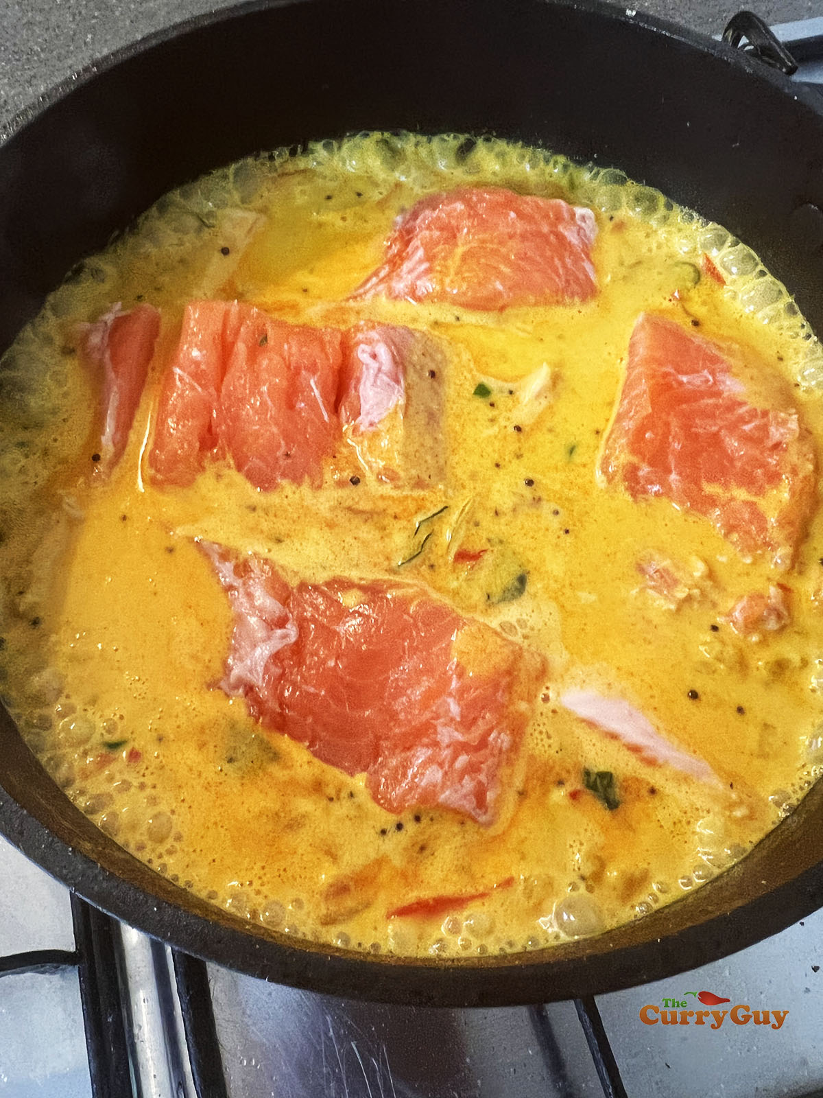 Salmon simmering in sauce