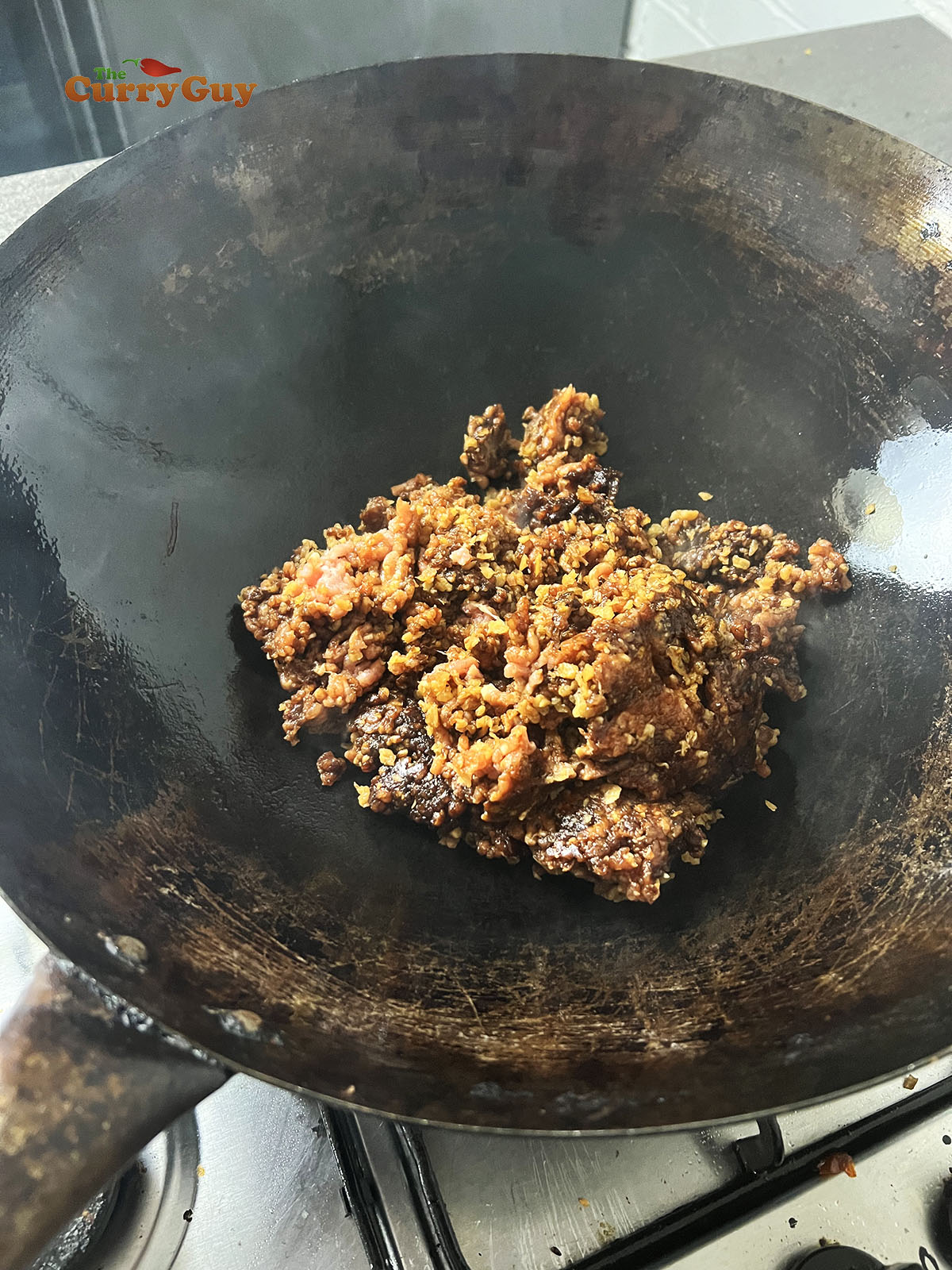 Adding meat to the wok.