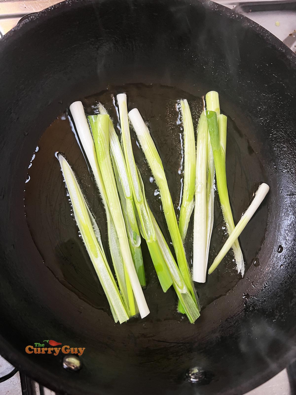 Frying spring onions (scallions) in a little oil.
