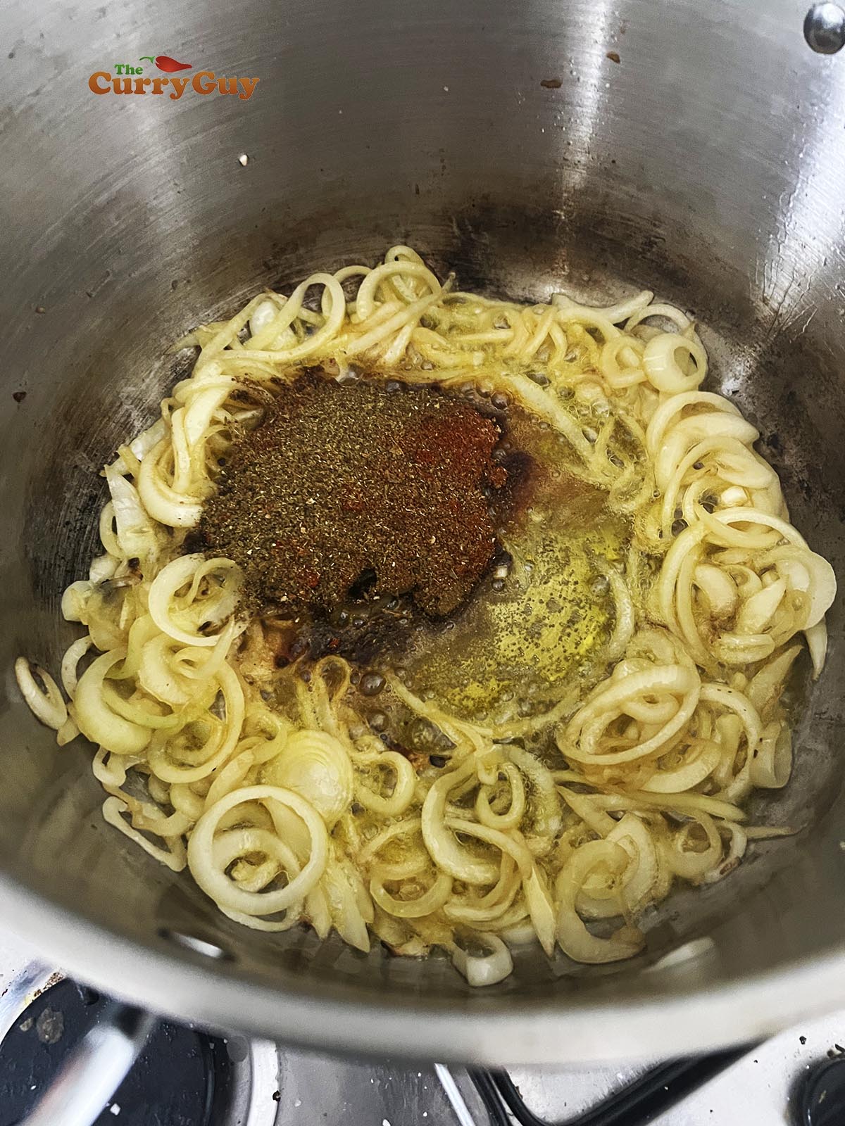 Stirring ground spices into the fried onions.