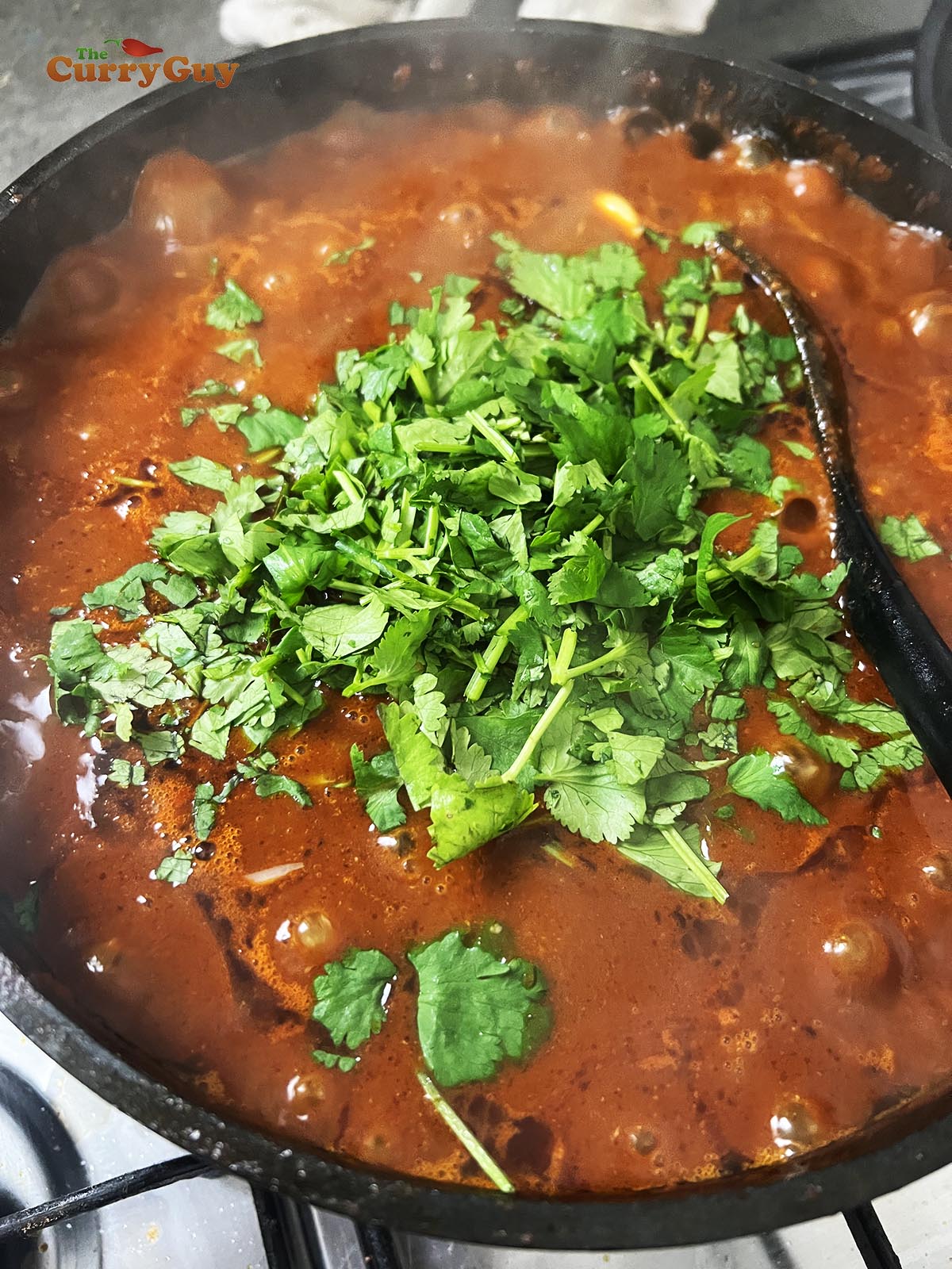 Stirring in the beans and coriander (cilantro).