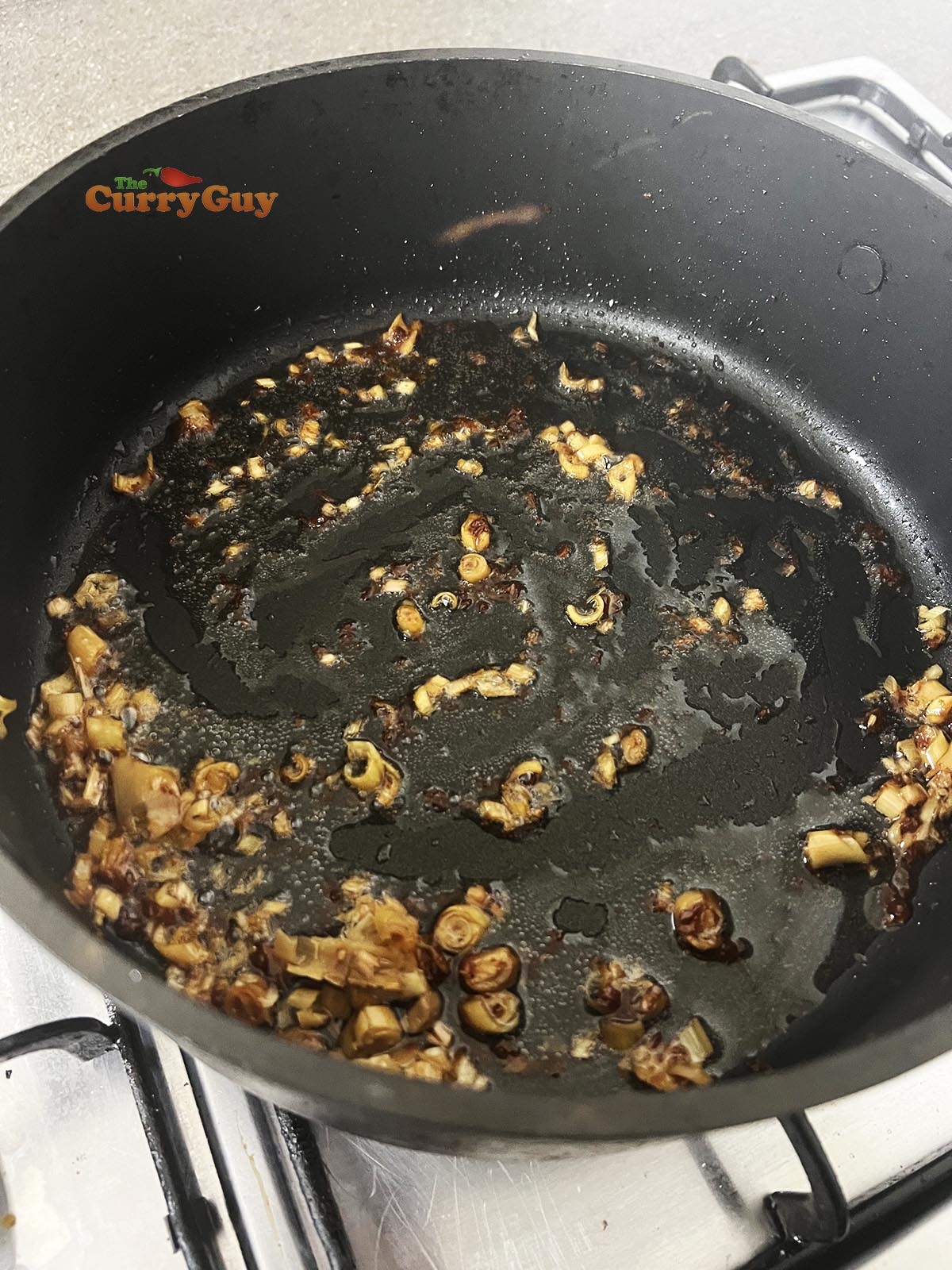 Frying lemongrass and shrimp paste in coconut oil. 
