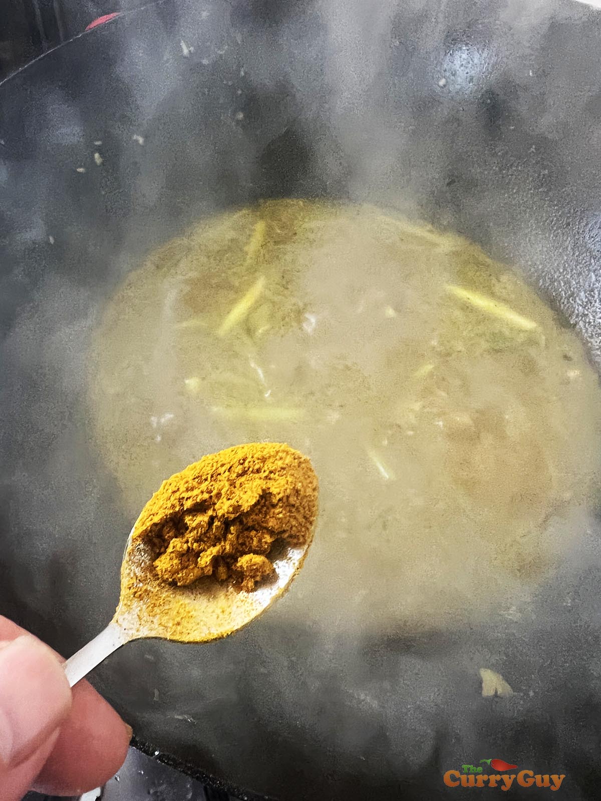 Adding curry powder to the stock.