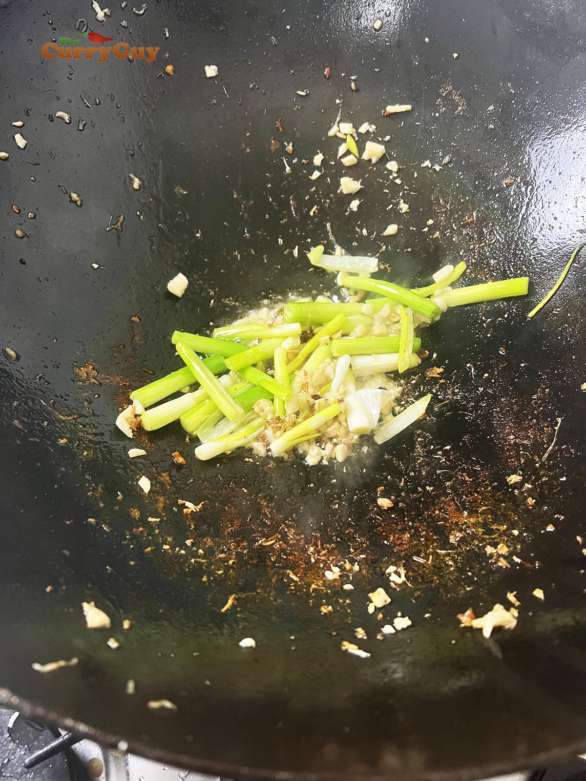 Frying garlic, galangal and spring onions (scallions)