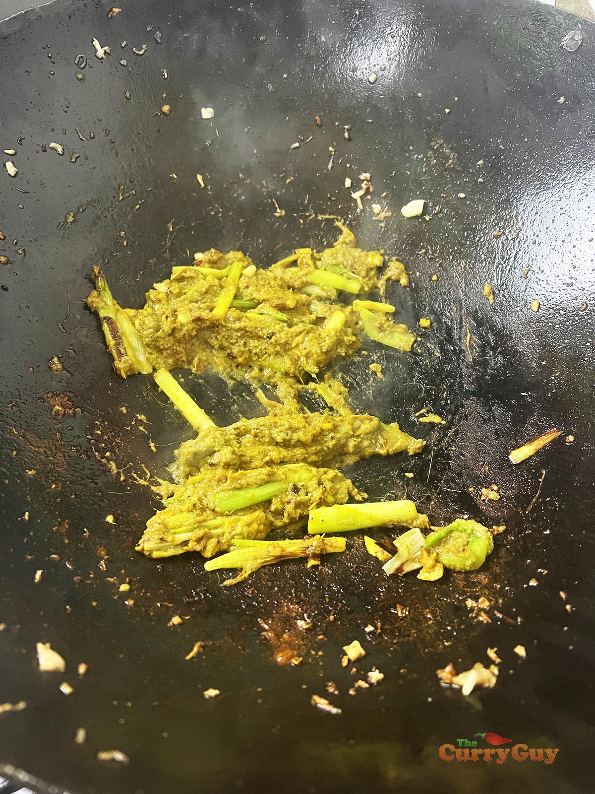 Adding curry paste to the pan.