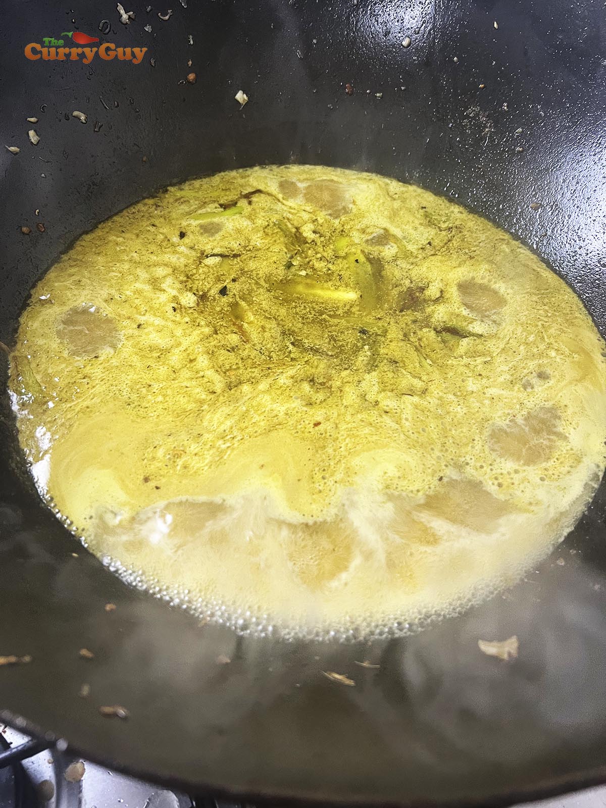 Simmering chicken stock in the pan.
