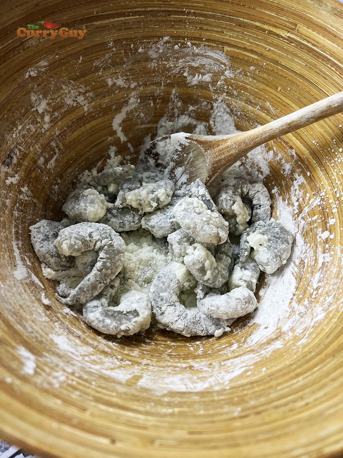 Coating the prawns with flour.