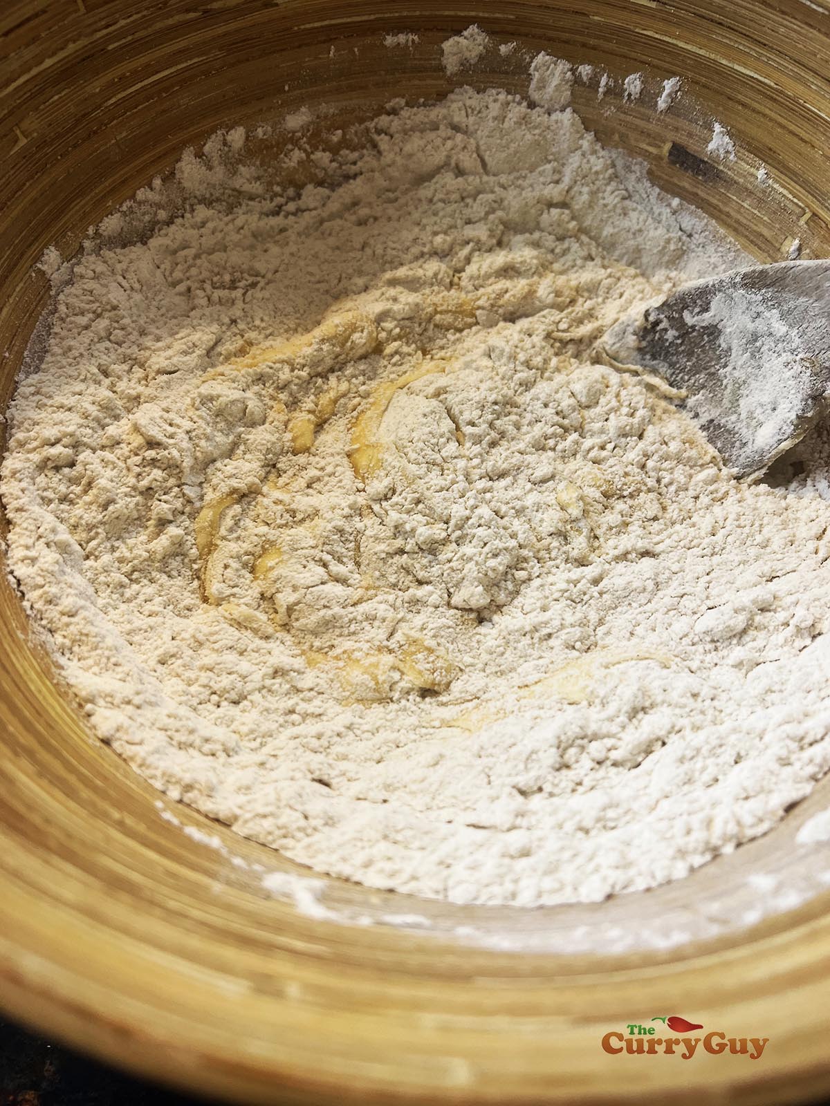 Adding whisked eggs to flours to make the batter