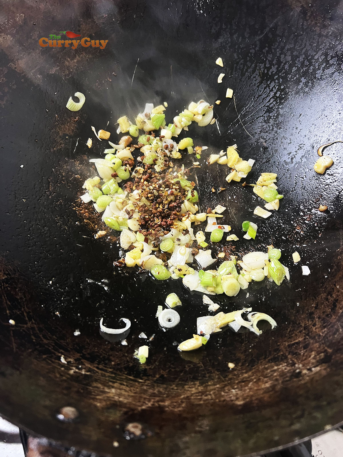 Adding Szechuan peppercorns and chilli flakes.