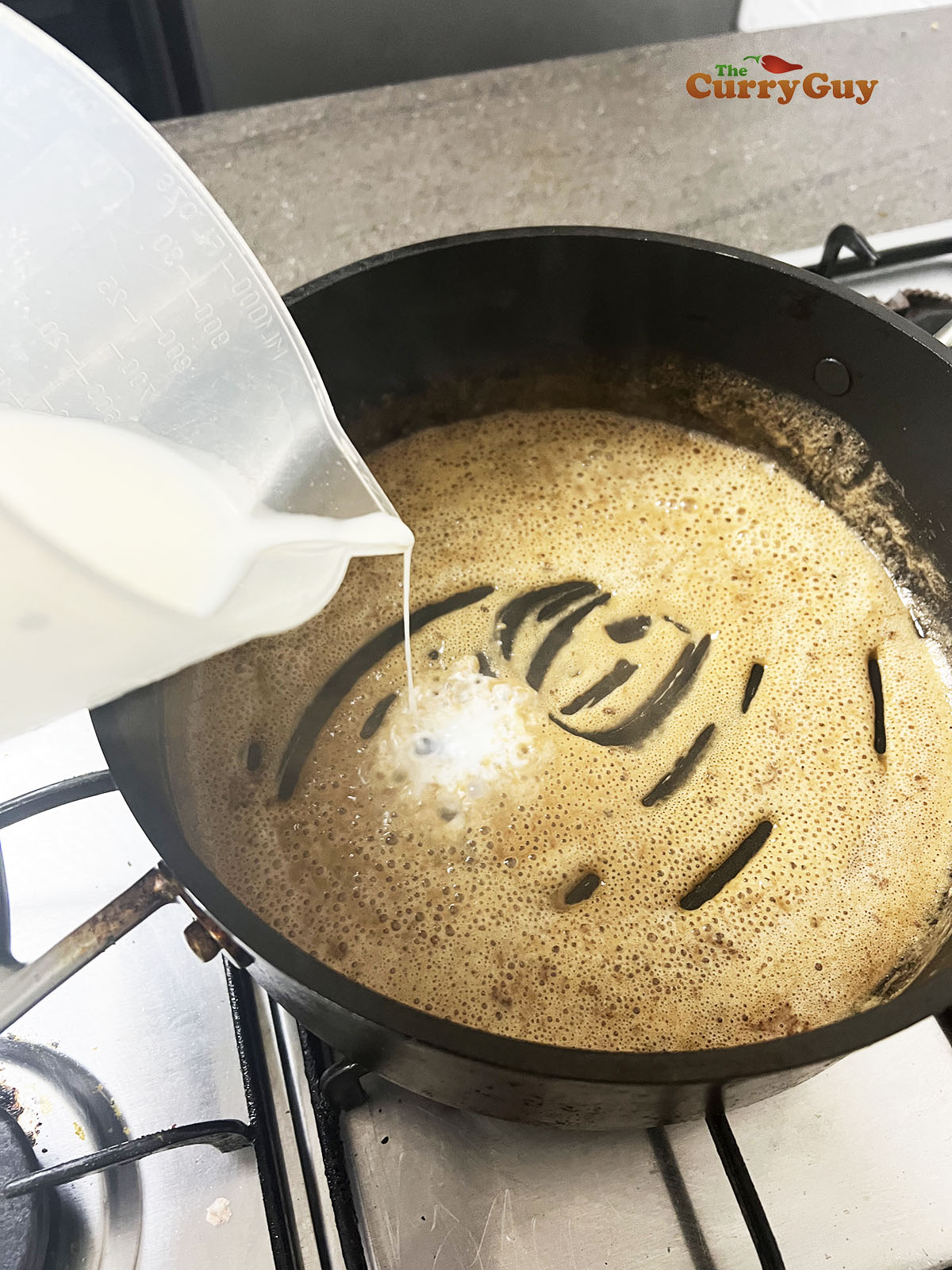 Slowly adding milk to the roux.