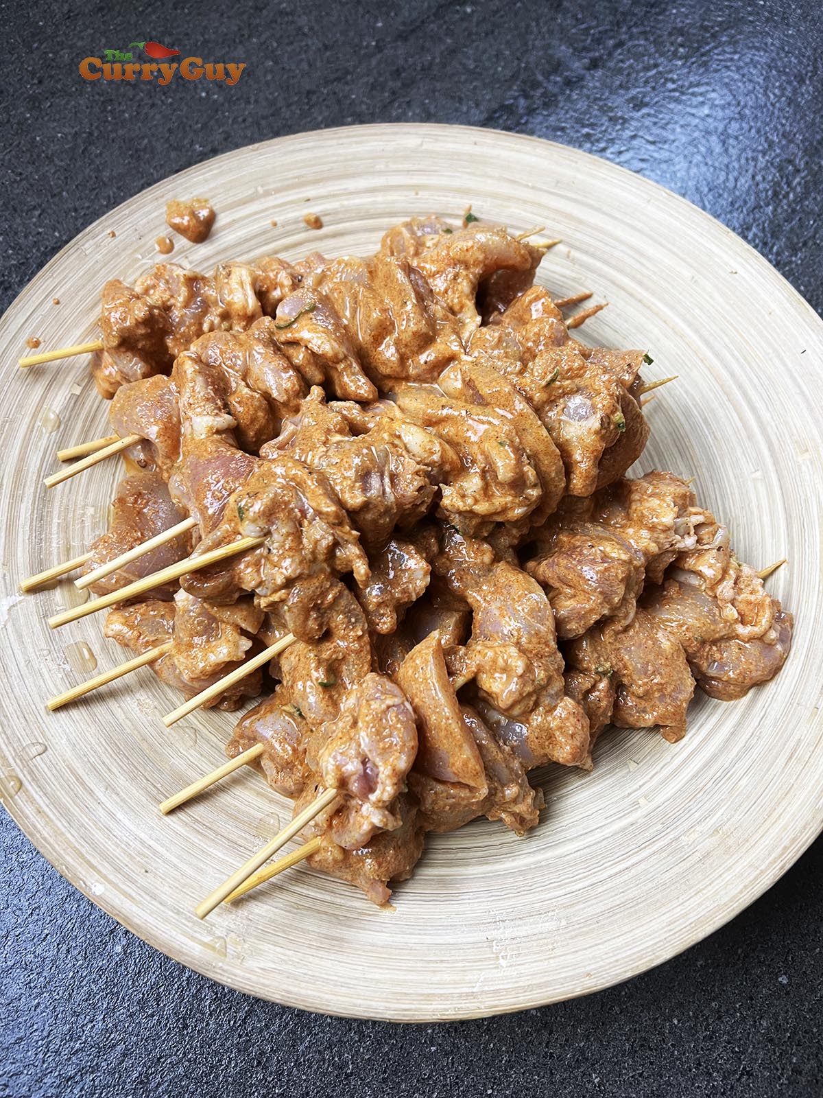 Chicken skewered onto wooden skewers.