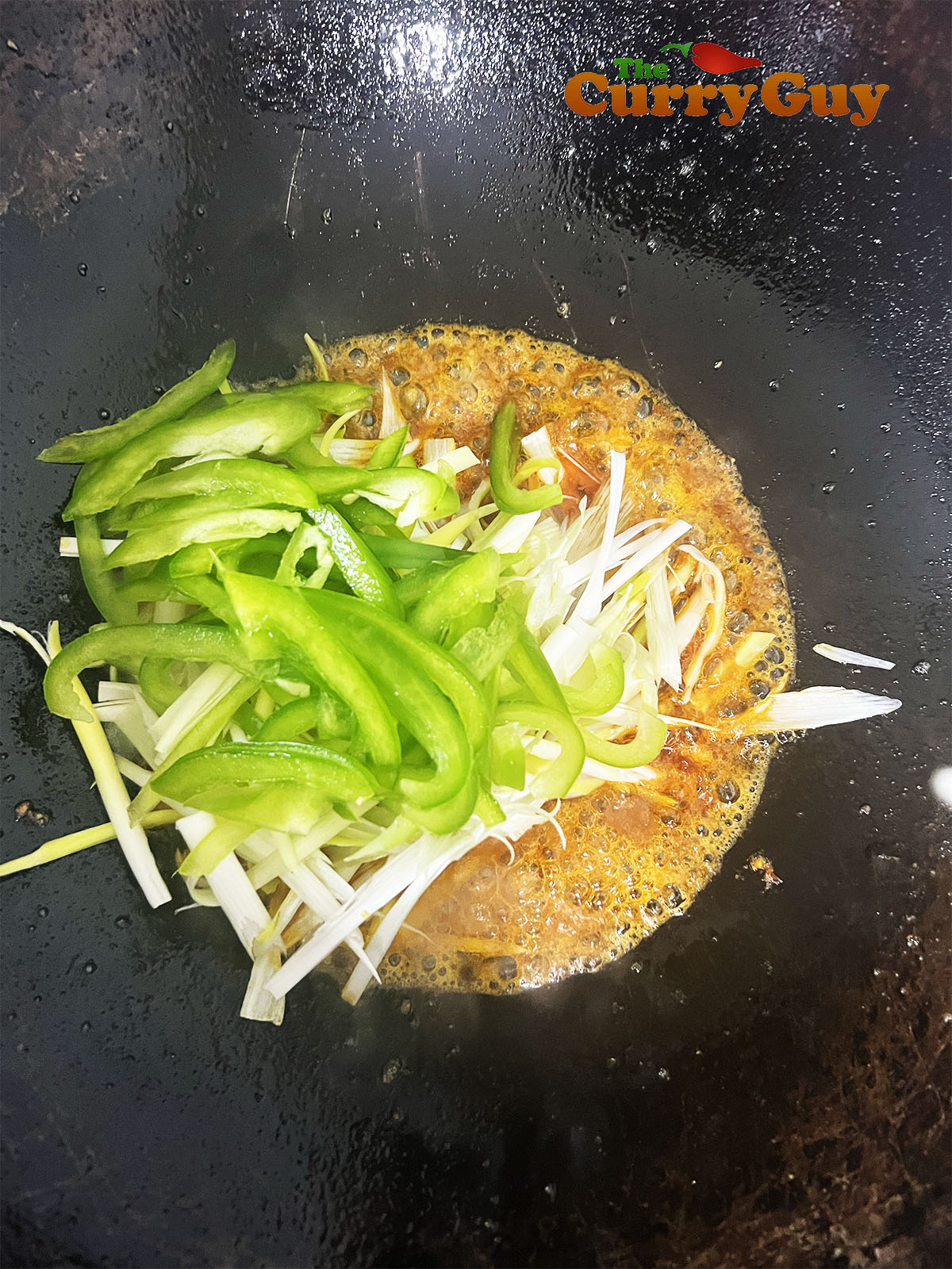 Spring onions and bell pepper being added.