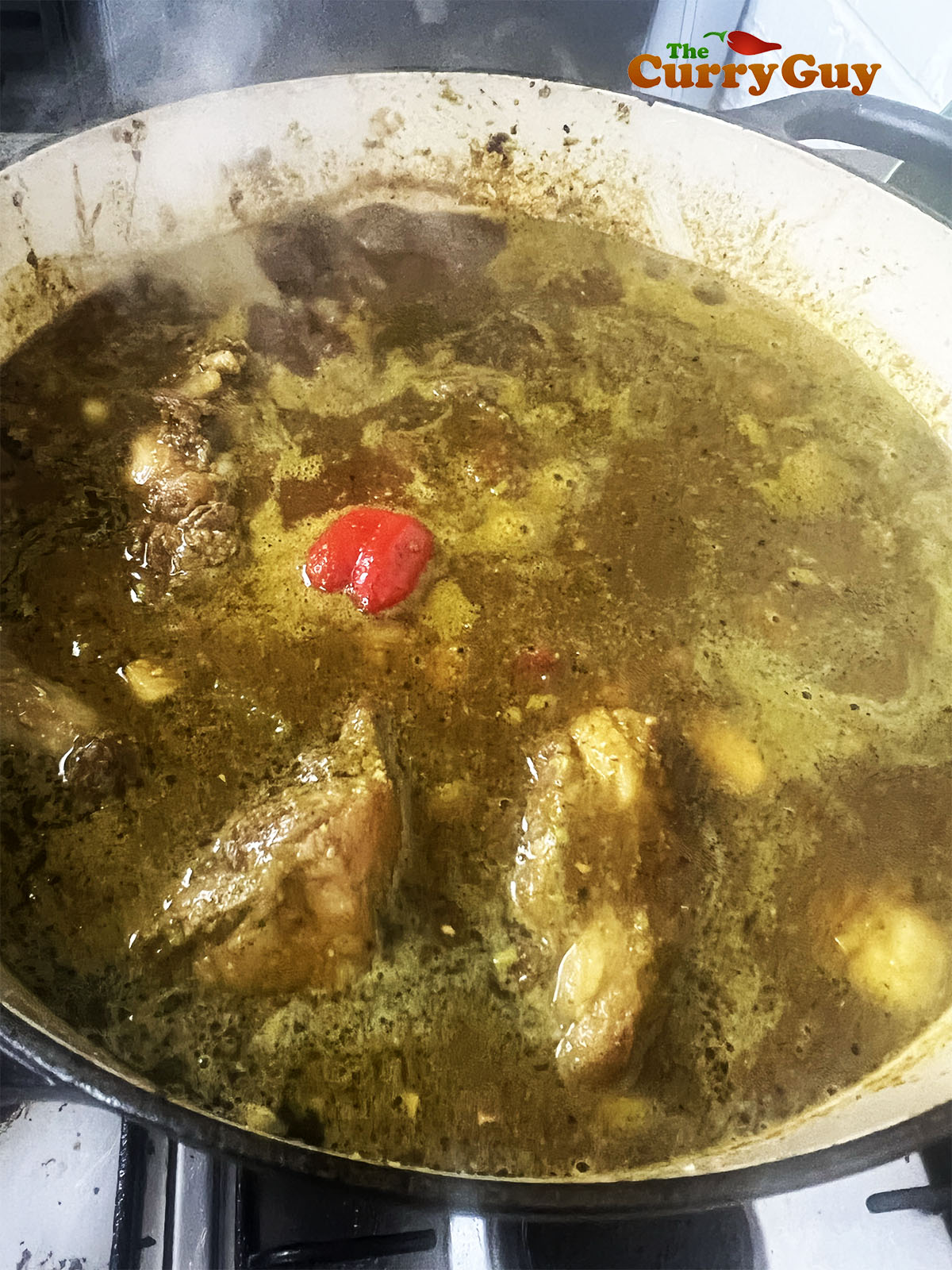 Adding the chilli and beef stock to the pan.